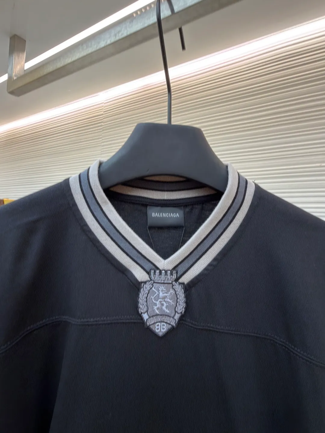 Balenciaga team series V-neck long sleeves ●Original version: purchased and developed by 8016 ●Item number: 1682073-A55 ●Fabric: plain knitted compact cotton fabric ●Technology: glue printing ●Color: black ●Version: loose version ●Weight: about 380 grams ●Size: XS-S-M-L ●Description: The main body is made of 24-count special woven compact cotton, with a weight of 185g/㎡. Compact spinning technology is applied in the spinning process, which significantly reduces yarn hairiness and makes the yarn smoother and stronger. This gives the fabric an unusually dense structure, a smooth and smooth surface, and excellent pilling resistance, while retaining the softness and breathability of pure cotton. The weight of 185g is light to middleweight, ensuring that the clothing is light, drapeable and can move freely. It is very suitable for creating a long-sleeved shirt that combines sportiness with daily comfort. The V-neck part is made of two different colors of high-elastic rib fabrics. The process step is to first weave ribbed belts of two colors separately, and then through precise cutting and splicing, form a V-shaped neckline with sharp color contrast. It breaks the monotony of the solid color body, uses strong color contrast to create a young and energetic visual focus, and optimizes the neck line. The pattern is pre-cut and formed into patches on fabrics of different materials or colors, and then covered on the body. Finally, high-density embroidery thread is used to fix the edges and outline the internal details. Its function is to create patterns with bright colors, strong texture contrast, three-dimensionality and durability. The edges of the pattern are strong and not easy to wear. A special elastic paste is screen-printed on the sleeves to create brightly colored patterns with a slightly coated feel. The elastic paste ensures that the printed area can stretch with the fabric without cracking. It forms a texture contrast between one flat and one convex with the three-dimensional sense of appliqué, which increases the interest and complexity of the design. The overall wiring is straight and delicate, the fabric is comfortable and soft, and the color is consistent without color difference. It can be matched with the same style to create a fashionable look and control various occasions. Customized accessories, complete with three standards, same style for men and women!