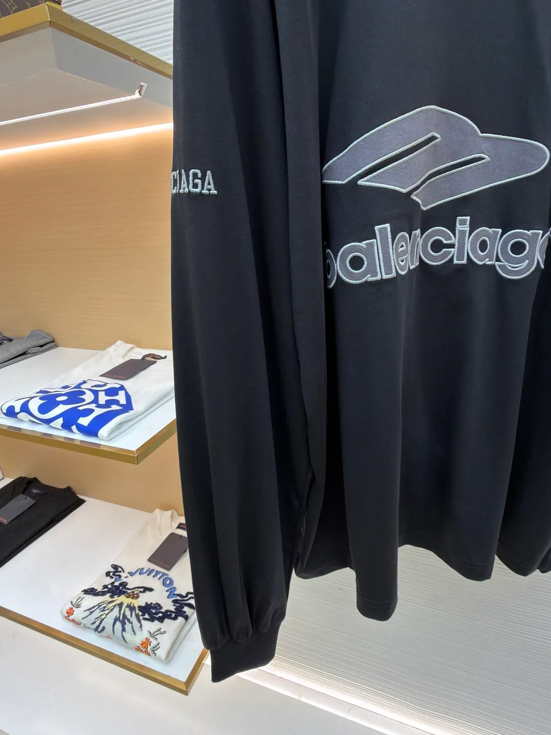 Balenciaga team series V-neck long sleeves ●Original version: purchased and developed by 8016 ●Item number: 1682073-A55 ●Fabric: plain knitted compact cotton fabric ●Technology: glue printing ●Color: black ●Version: loose version ●Weight: about 380 grams ●Size: XS-S-M-L ●Description: The main body is made of 24-count special woven compact cotton, with a weight of 185g/㎡. Compact spinning technology is applied in the spinning process, which significantly reduces yarn hairiness and makes the yarn smoother and stronger. This gives the fabric an unusually dense structure, a smooth and smooth surface, and excellent pilling resistance, while retaining the softness and breathability of pure cotton. The weight of 185g is light to middleweight, ensuring that the clothing is light, drapeable and can move freely. It is very suitable for creating a long-sleeved shirt that combines sportiness with daily comfort. The V-neck part is made of two different colors of high-elastic rib fabrics. The process step is to first weave ribbed belts of two colors separately, and then through precise cutting and splicing, form a V-shaped neckline with sharp color contrast. It breaks the monotony of the solid color body, uses strong color contrast to create a young and energetic visual focus, and optimizes the neck line. The pattern is pre-cut and formed into patches on fabrics of different materials or colors, and then covered on the body. Finally, high-density embroidery thread is used to fix the edges and outline the internal details. Its function is to create patterns with bright colors, strong texture contrast, three-dimensionality and durability. The edges of the pattern are strong and not easy to wear. A special elastic paste is screen-printed on the sleeves to create brightly colored patterns with a slightly coated feel. The elastic paste ensures that the printed area can stretch with the fabric without cracking. It forms a texture contrast between one flat and one convex with the three-dimensional sense of appliqué, which increases the interest and complexity of the design. The overall wiring is straight and delicate, the fabric is comfortable and soft, and the color is consistent without color difference. It can be matched with the same style to create a fashionable look and control various occasions. Customized accessories, complete with three standards, same style for men and women!
