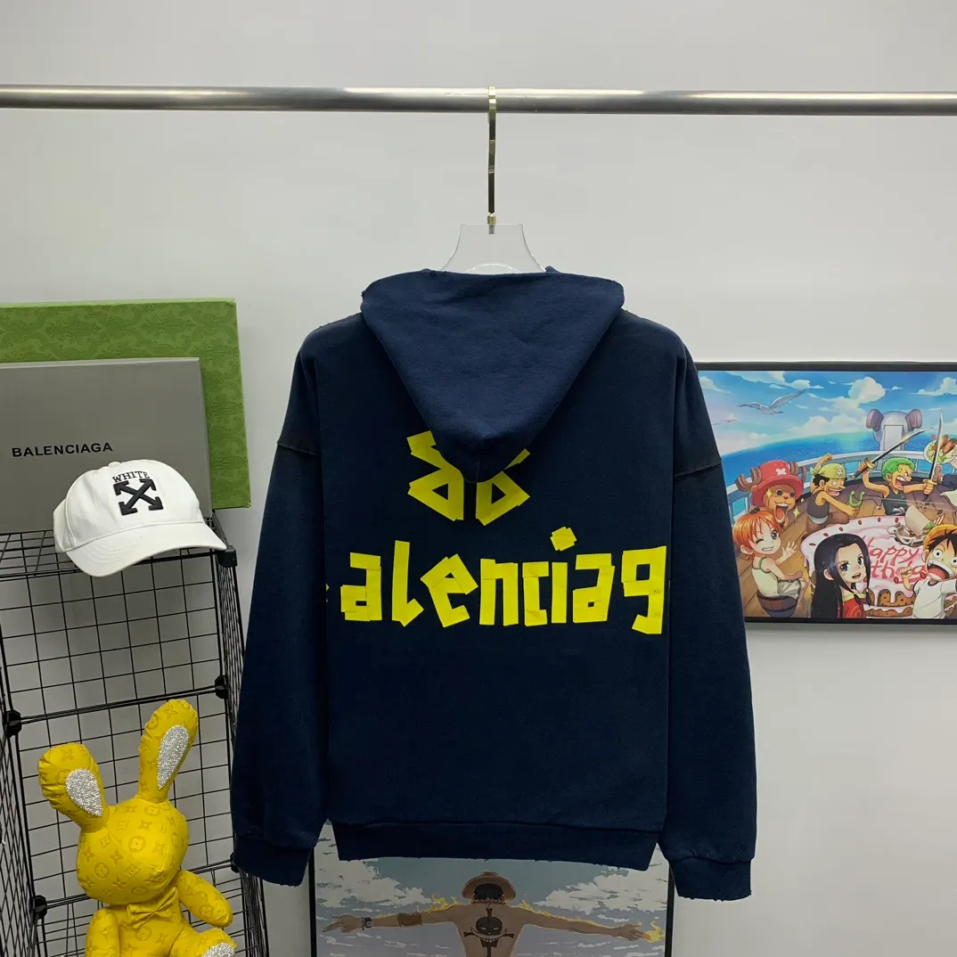 The top proven version of Balenciaga 23SS masking paper printed letters double-sided logo hooded loose hooded sweatshirt. This hoodie has a very interesting and cute design. The kangaroo pocket on the front of the large body is reverse-cut design. The double side pockets are hollow, which means that when viewed from the front, it actually deceives your vision. The real pockets are sewn on the reverse terry bottom. It is time-consuming and labor-intensive, but it is the core theme of the entire hoodie that cannot be ignored. The same detail is that the double side pockets are hemmed and stitched. And processed with holes; 480g heavy-weight pure cotton fabric with fine small terry bottom. After heavy mud dyeing and washing, the fabric still has a thick foundation and is comfortable and soft. The front and back double-sided textured paper transfer LOGO, and the front and back printing colors are different. The loose and large drop shoulder design is unisex. This style is also very suitable for girls to match. It is easy to create a lazy and casual street feel of the United States and France. Many holes are processed by hand grinding wheels on the body. Traces of muddying can be seen on the neckline, shoulder line, and side cuff splicing, but the visual effect transition is natural and soft without any sense of dirt. The old effect of the entire hoodie is excellent. The cuff threads are custom-woven in color; the packaging is washed and customized. The new gray silver letter main logo. The dropped shoulder model does not include shoulder width. The version is Kanye’s American style. Short and wide street casual version. From short sleeves to sweaters, this style is definitely not to be missed. Color: mud-dyed custom-woven navy Size: XS-S-M (Can be worn by both men and women, OS is loose and dropped on the shoulders) P:510