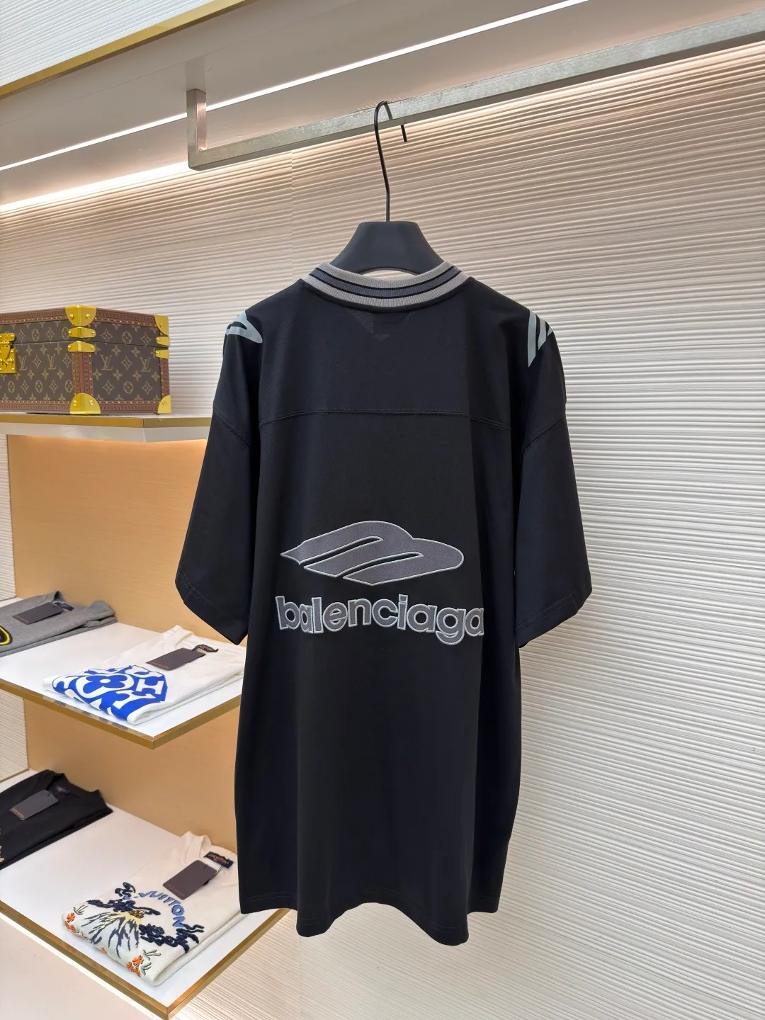 Balenciaga Team Series V-neck Short Sleeve ●Original version: Purchased and developed by 6898 ●Item No.: 1682042-A50 ●Fabric: Jersey compact cotton fabric ●Technology: Glue printing ●Color: Black ●Version: Loose version ●Weight: about 310 grams ●Size: Compact spinning technology is applied in the spinning process, which significantly reduces yarn hairiness and makes the yarn smoother and stronger. This gives the fabric an unusually dense structure, a smooth and smooth surface, and excellent pilling resistance, while retaining the softness and breathability of pure cotton. The weight of 185g is light to middleweight, ensuring that the clothing is light, drapeable and can move freely. It is very suitable for creating a long-sleeved shirt that combines sportiness with daily comfort. The V-neck part is made of two different colors of high-elastic rib fabrics. The process step is to first weave ribbed belts of two colors separately, and then through precise cutting and splicing, form a V-shaped neckline with sharp color contrast. It breaks the monotony of the solid color body, uses strong color contrast to create a young and energetic visual focus, and optimizes the neck line. The pattern is pre-cut and formed into patches on fabrics of different materials or colors, and then covered on the body. Finally, high-density embroidery thread is used to fix the edges and outline the internal details. Its function is to create patterns with bright colors, strong texture contrast, three-dimensionality and durability. The edges of the pattern are strong and not easy to wear. A special elastic paste is screen-printed on the sleeves to create brightly colored patterns with a slightly coated feel. The elastic paste ensures that the printed area can stretch with the fabric without cracking. It forms a texture contrast between one flat and one convex with the three-dimensional sense of appliqué, which increases the interest and complexity of the design. The overall wiring is straight and delicate, the fabric is comfortable and soft, and the color is consistent without color difference. It can be matched with the same style to create a fashionable look and control various occasions. Customized accessories, complete with three standards, same style for men and women!
