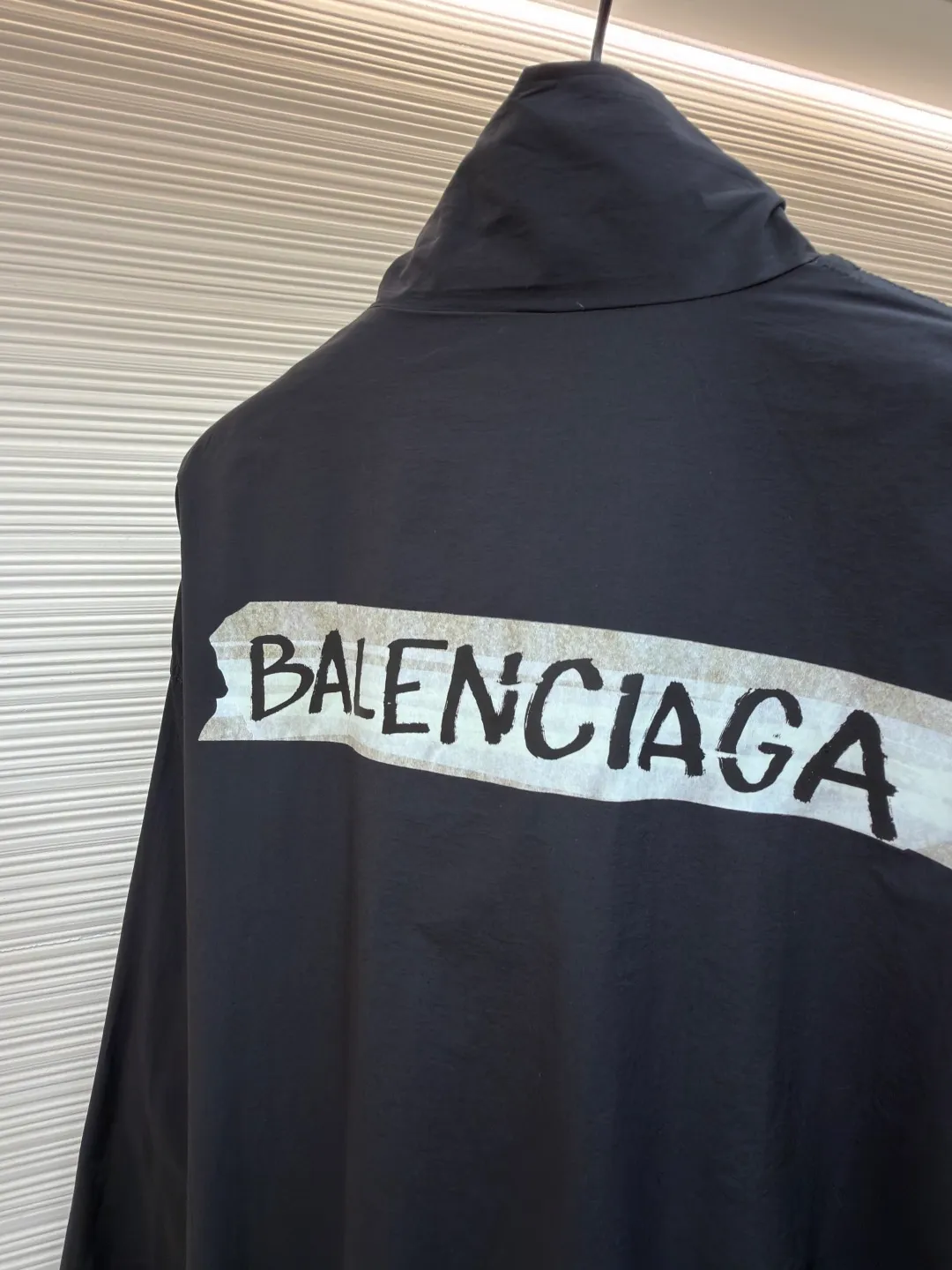 Balenciaga glue print jacket ●Original version: Purchased and developed for 20000 ●Item number: 1682403-B40 ●Fabric: woven nylon fabric ●Technology: glue printing production ●Color: black ●Version: fitted version ●Weight: about 480 grams ●Size: XS-S-M ●Description: This Balenciaga cotton blended jacket is made of 65% cotton and 35% polyester fiber blended fabric. It is first processed by a high-temperature pre-shrinking process to control the fabric shrinkage within 1% to avoid deformation after wearing and washing. The brand logo on the front of the body is made using glue printing technology. Before printing, the fabric is statically eliminated, and then the glue is tightly combined with the fabric through 150℃ high temperature printing. The pattern is clear, does not fall off and is friction-resistant. The jacket adopts a stand-up collar zipper design. The metal zipper has been treated with anti-oxidation plating and is smooth and easy to pull. The cuffs and hem are made of elastic ribbing. The rib weaving method is 1*1 double-needle technology, which is durable and not easy to loosen. The side seam pockets use invisible inlay technology with a stitch density of 8 stitches per centimeter. The shoulders are seamlessly taped. The overall craftsmanship takes into account the brand's iconic simple design and durability, and the details highlight the production standards of high-end clothing. The overall wiring is straight and delicate, the fabric is comfortable and soft, and the color is consistent without color difference. It can be matched with the same style to create a fashionable look and control various occasions. Customized accessories, complete with three standards, same style for men and women!