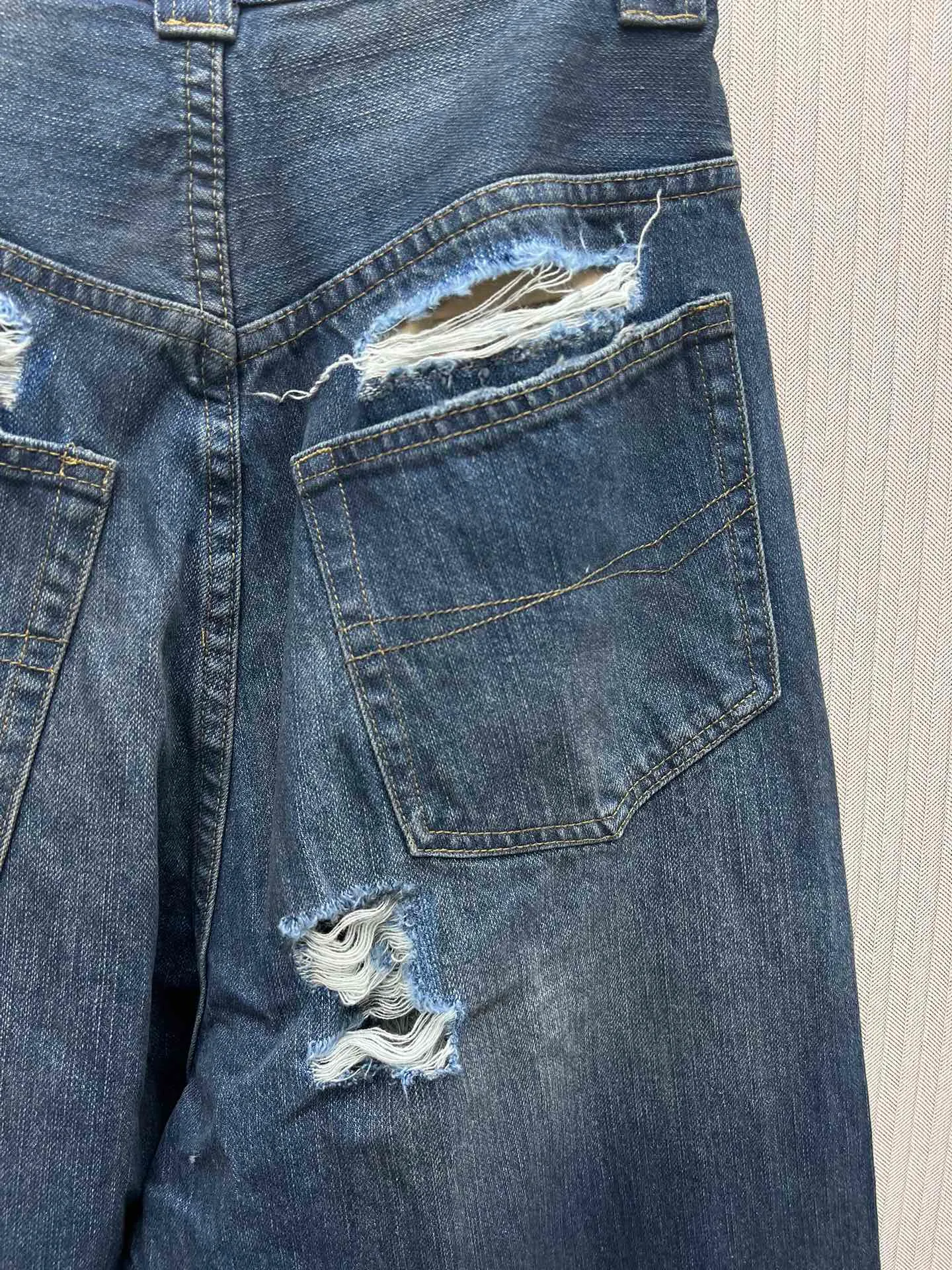 🅿️490 Paris Blcg 25 destroyed denim wide-leg pants. The fabric is made of high-density pure cotton twill denim imported from Italy. The loss of narrow-width fabrics is great to restore the loose and drooping feeling. The fabric is first washed and de-padded. The washing process needs to be repeated 3 times to restore the color. It is washed and sanded to form an aged texture. The color is too natural. Finally, a professional painter is required to spray dirty transitions. Custom-woven and dyed trouser fabrics. Pocket fabrics. The entire thickness. The material is consistent with YB. The cuts are positioned and damaged. Hand-made grinding and hand-picking. A complete set of customized accessories. Bronze hardware with fine flat nails. The details of the mold-opening custom shake-button buckle are synchronized. Mid-rise jeans. Loose jeans. Size: XS.S.M.