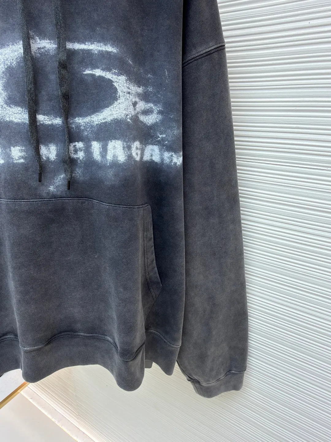 Balenciaga faded washed smoke print sweatshirt ●Original version: Purchased and developed by 6347 ●Item number: 1682524-B25 ●Fabric: Heavy fleece fabric ●Technology: smoke smudged production ●Color: distressed gray ●Version: loose fit ●Weight: about 825 grams ●Size: XS-S-M-L ●Description: The material I chose is heavy fleece fabric with a fine knitted texture on the surface, which is soft but not collapsed; the old charcoal gray color looks like it has been covered by a layer of fog, and the uneven washing marks have a "relaxed feeling that I love more and more after wearing it N times". It is not deliberately dirty, but just the right retro filter. The iconic "double rings + letters" are processed into a "smoke smudge" blur effect, like casually splashed white ink smearing on gray cloth, without sharp edges. The washing process of the entire garment is superb: the whitened edges of the collar and cuffs, the naturally faded texture of the garment, and even the woven threads of the drawstring have a slight "old feel". It is not a one-time Internet celebrity model, but a "culture-based" item that will become more natural with wrinkles the longer it is worn. It has just the right drop-shoulder silhouette - the shoulder line has dropped 1cm, which prevents it from collapsing into "boyfriend clothes" and gives it a lazy street feel. The length of the garment covers the hip bones and can be worn with cycling pants to expose the ankles, or with overalls piled on top of the shoes. It looks effortlessly cool no matter how you wear it. The overall wiring is straight and delicate, the fabric is comfortable and soft, and the color is consistent without color difference. It can be matched with the same style to create a fashionable look and control various occasions. Customized accessories, complete with three standards, same style for men and women!