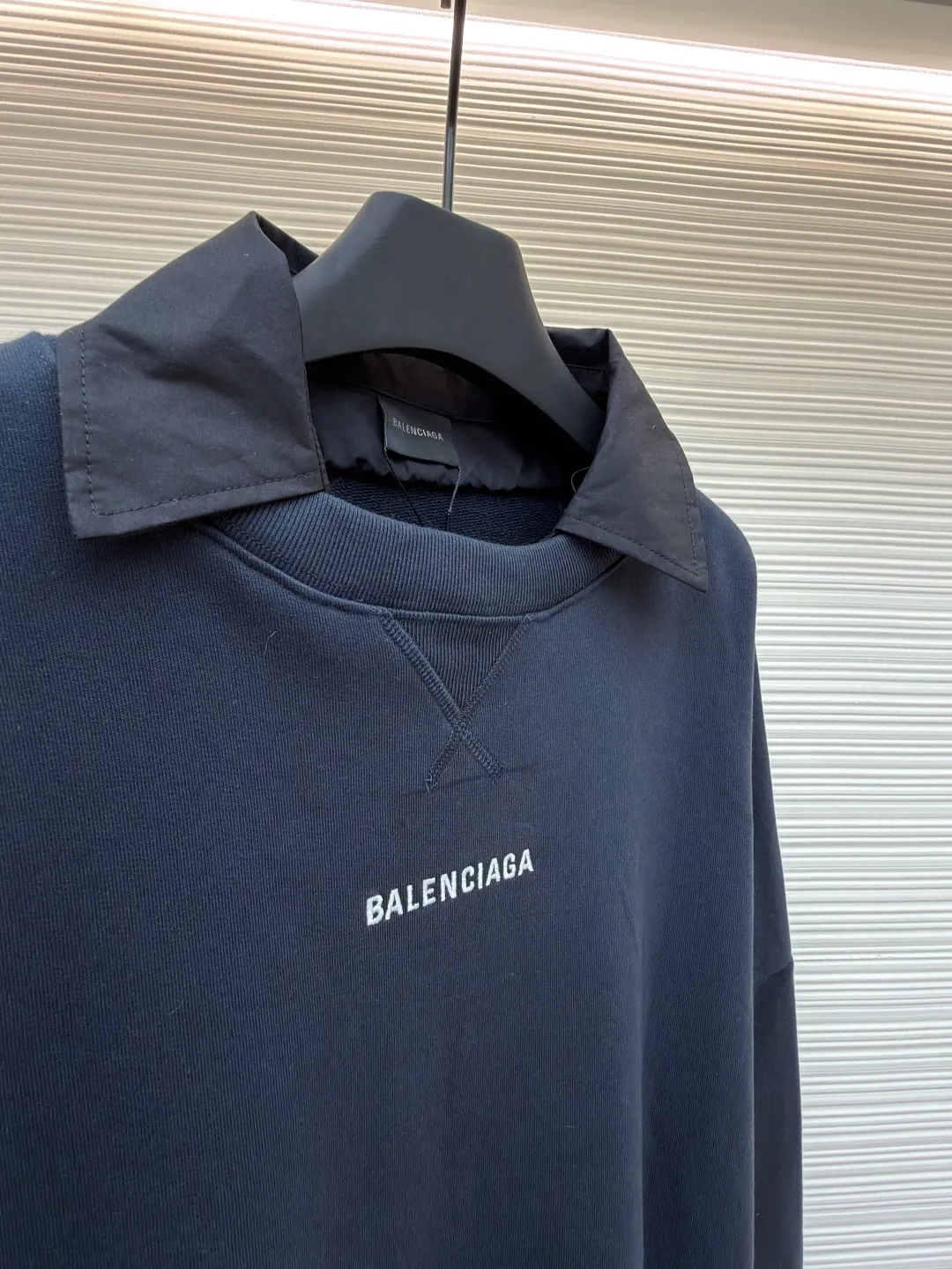 Balenciaga fake two-piece collared crew neck sweatshirt ●Original version: purchased and developed by 7652 ●Item number: 1681727-A50 ●Material: combed cotton fabric ●Technology: embroidery production ●Color: royal blue ●Version: fitted version ●Weight: about 785 grams ●Size: S-M-L-XL ●Description: The fabric is made of custom-woven and dyed 400 grams combed cotton, and the weight is the key indicator to measure the thickness of the fabric. 400 grams belongs to the high weight category, which gives the sweatshirt excellent stiffness, drape and warmth. This sense of weight does not attach softly to the body, but can build the architectural silhouette that Demna is pursuing. During the spinning process, the shorter cotton fibers and impurities are removed, leaving longer, stronger fibers. This makes the final fabric smoother, stronger, and less prone to pilling, essentially improving durability and premium feel. The splicing line between the collar and the sweatshirt body must be clean and neat, and the transition relationship between the inner and outer layers needs to be calculated just right. This is a kind of "deliberate randomness" whose complexity is much higher than actually wearing two pieces of clothing. It challenges the traditional definition of "a piece of clothing" and is the embodiment of Demna's signature deconstruction and reorganization techniques. It combines two clothing with different functions (formal collar and casual sweatshirt) to create a new species full of contradictions and interest. The overall wiring is straight and delicate, the fabric is comfortable and soft, and the color is consistent without color difference. It can be matched with the same style to create a fashionable look and control various occasions. Customized accessories, complete with three standards, same style for men and women!