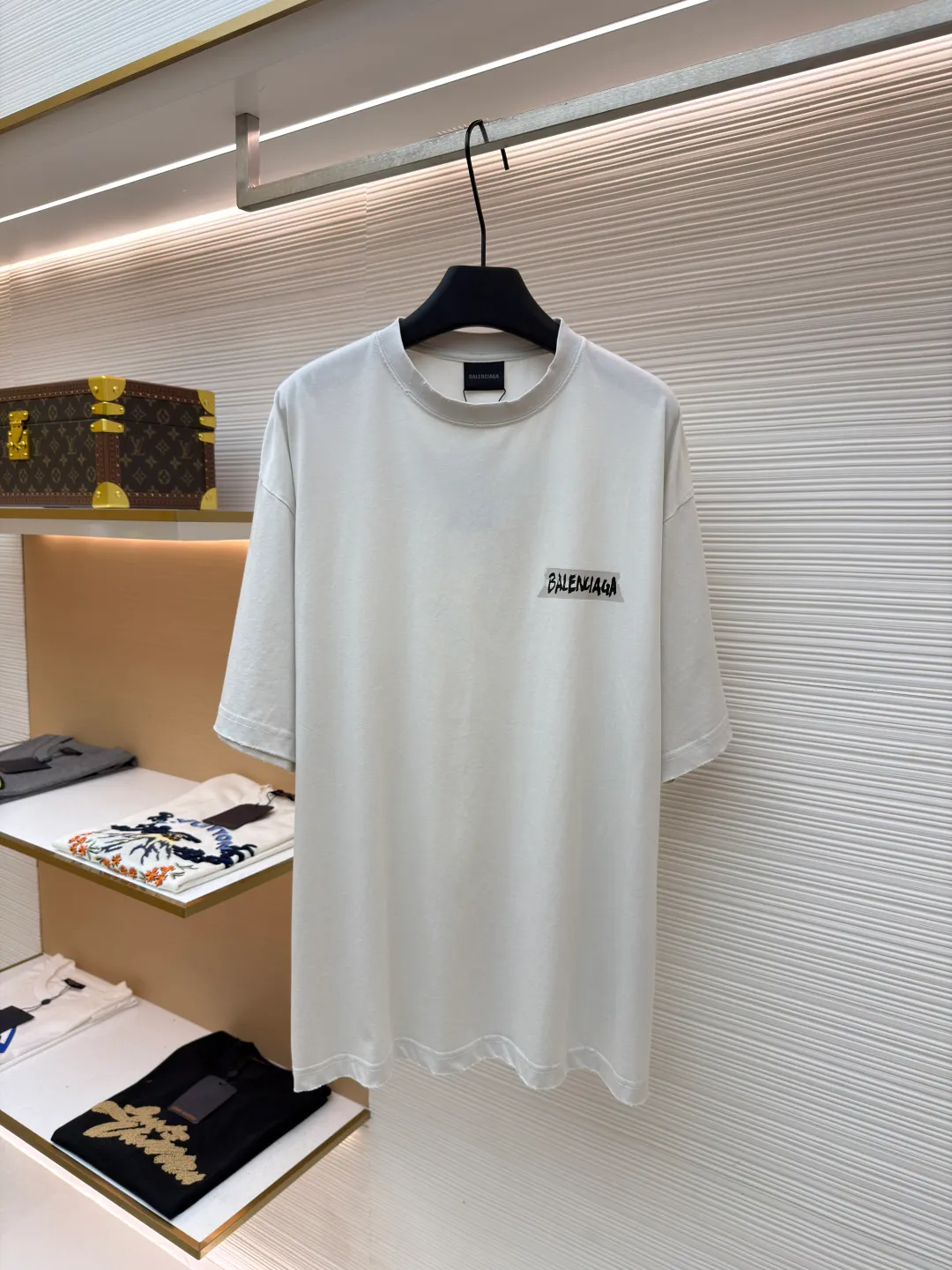 Balenciaga white background glue printed round neck short sleeves ●Original version: purchased and developed for 6500 ●Item number: 1681596-A15 ●Fabric: retro plain knitted fabric ●Technology: Glue printing production ●Color: white ●Version: fitted version ●Weight: about 255g ●Size: Thread, weight is 270g. The weight of the fabric ensures lightness and breathability. The 24-count yarn gives the fabric a delicate and smooth texture, and the plain knitted structure brings good skin-friendliness and moderate elasticity. The fabric has been washed in faded gray, which not only gives it a unique retro look and softens the color, but also achieves a pre-softening effect on the touch, eliminating the stiffness of new fabric and giving the garment a comfortable and soft old material feel when worn for the first time. Dark floral dot multi-layer overlay printing is an advanced printing technology that combines fine patterns and three-dimensional layers. Its core is to use high-mesh dot plate making to overprint transparent or light-colored printing paste on the fabric base multiple times with micron-level precision. Each overlay is accurately aligned to form a faint dark flower texture. The printing pattern does not rely on bright colors, but creates subtle light and shadow gradients and tactile layering on the surface of the fabric through the thickness difference of slurry accumulation and light refraction. The pattern shows subtle changes at different angles, combining visual depth and long-lasting washability. The overall wiring is straight and delicate, the fabric is comfortable and soft, and the color is consistent without color difference. It can be matched with the same style to create a fashionable look and control various occasions. Customized accessories, complete with three standards, same style for men and women!