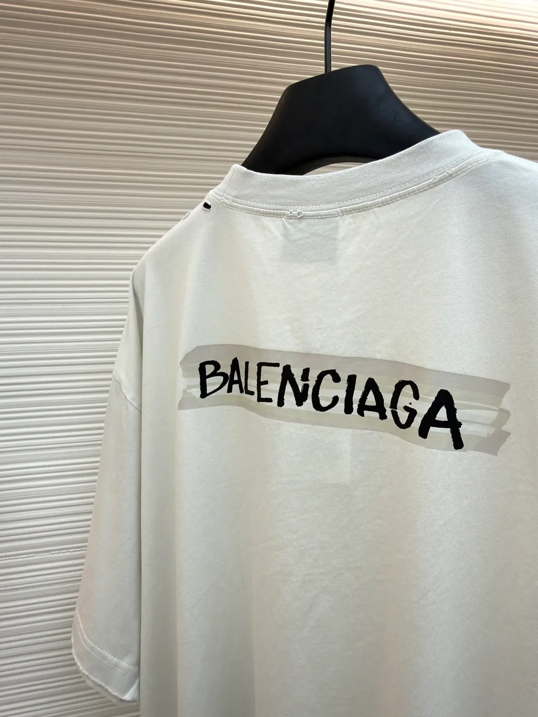 Balenciaga white background glue printed round neck short sleeves ●Original version: purchased and developed for 6500 ●Item number: 1681596-A15 ●Fabric: retro plain knitted fabric ●Technology: Glue printing production ●Color: white ●Version: fitted version ●Weight: about 255g ●Size: Thread, weight is 270g. The weight of the fabric ensures lightness and breathability. The 24-count yarn gives the fabric a delicate and smooth texture, and the plain knitted structure brings good skin-friendliness and moderate elasticity. The fabric has been washed in faded gray, which not only gives it a unique retro look and softens the color, but also achieves a pre-softening effect on the touch, eliminating the stiffness of new fabric and giving the garment a comfortable and soft old material feel when worn for the first time. Dark floral dot multi-layer overlay printing is an advanced printing technology that combines fine patterns and three-dimensional layers. Its core is to use high-mesh dot plate making to overprint transparent or light-colored printing paste on the fabric base multiple times with micron-level precision. Each overlay is accurately aligned to form a faint dark flower texture. The printing pattern does not rely on bright colors, but creates subtle light and shadow gradients and tactile layering on the surface of the fabric through the thickness difference of slurry accumulation and light refraction. The pattern shows subtle changes at different angles, combining visual depth and long-lasting washability. The overall wiring is straight and delicate, the fabric is comfortable and soft, and the color is consistent without color difference. It can be matched with the same style to create a fashionable look and control various occasions. Customized accessories, complete with three standards, same style for men and women!