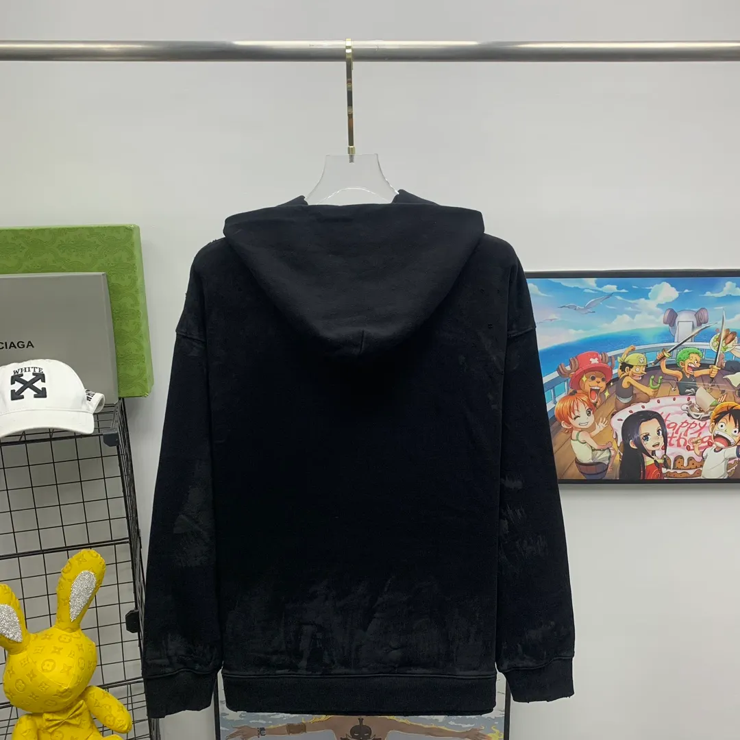 Top tested version 23FW BALENCIAGA Paris Manchester United limited edition distressed male and female couple star same style pure cotton loose hooded sweatshirt [very suitable for Douyin, and other platforms! The letters in the LOGO position have been damaged and polished! 】 The fabric is custom-made washed knitted cotton terry material. The upper body is very soft. The front panel uses a classic hand pocket with a worn effect. The overall yellow and dirty effect is all artificially sprayed with majolica. It requires proficiency and experience to achieve this natural and elegant effect!  Customized towel embroidery on the chest, heavily damaged! The aging effect is very obvious! The overall artificial positioning coating is hand-made, washed and dirty. The frayed hole craftsmanship has a hand-painted graffiti effect. The arms behind the bend are made of open-stitch frayed craftsmanship. The wiring is delicate. Elastic cuff design. The whole body is hand-positioned with muddy dyeing and frayed effect! Ready-made garments are washed twice with water +➕ once with wax. It feels smooth!   The Manchester United letters and logo on the chest are designed with full embroidery and the details are visible!  Size: XS-L Color: White Black P: 470