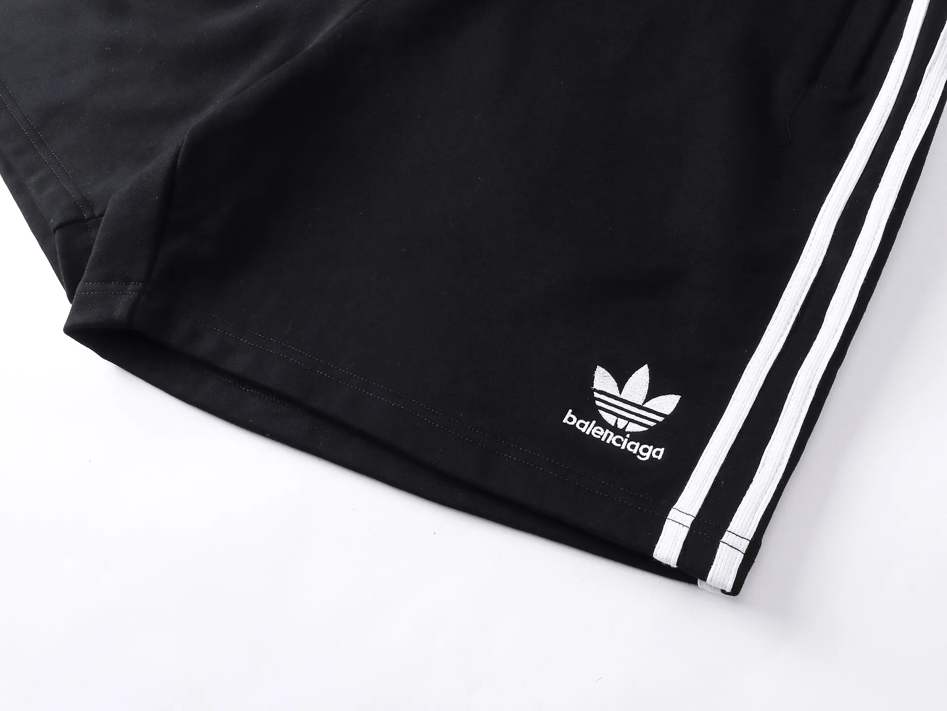 🅿️240 real shots [Top version. Official website quality] BALENCI*GA/Paris. 2025 new model. Paris co-branded adidas clover embroidered side seams. Invisible zipper shorts at the pocket. Brick cabinet synchronization. Genuine product developed at the first time, please print and compare! The fabric is made of Paris ZP custom-woven and dyed 100% cotton terry sweatshirt. The weight is 460 grams. The cloth surface is clean. The cloth pattern is clear and the hand feels soft and comfortable. The embroidery uses an imported Tajima embroidery machine. The letters are clear and the effect is three-dimensional. The version adopts a loose version. Same style for men and women. Code: BL257029 Color: black, white Size: XS S M L