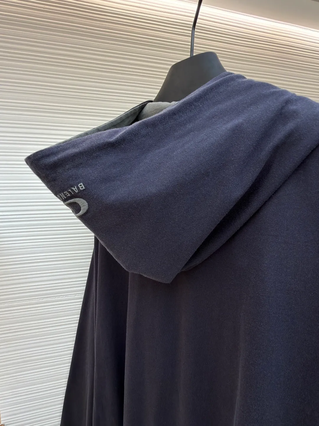 Balenciaga front and back double-layer hooded sweatshirt ●Original version: Purchased and developed by 9593 ●Item number: 1681294-B35 ●Fabric: Retro jersey fabric ●Technology: Washed production ●Color: black and gray ●Version: Loose version ●Weight: about 855 grams ●Size: Thread, weight is 270g. The weight of the fabric ensures lightness and breathability. The 24-count yarn gives the fabric a delicate and smooth texture, and the plain knitted structure brings good skin-friendliness and moderate elasticity. The fabric has been washed in faded gray, which not only gives it a unique retro look and softens the color, but also achieves a pre-softening effect on the touch, eliminating the stiffness of new fabric and giving the garment a comfortable and soft old material feel when worn for the first time. The main body of the gray surface embroidery adopts new tatami twill lace embroidery. The tatami embroidery stitches are intertwined and form diagonal lines. The tatami woven surface and the shaped edge integrally connected with the tatami woven surface. Good flatness, soft hand feel, good elasticity and good gloss. The woven surface of tatami is indented compared to the fixed edge, which improves the three-dimensional effect of the pattern and has a better visual effect. The black side uses precision needlepoint embroidery technology; the embroidery is very fine and dense, with clear patterns and strong lines and three-dimensionality. The linen material embroidery thread is combined with encrypted processing, and the embroidery body has a subtle matte visual texture; the embroidery effect is three-dimensional and full. The flat embroidery has a unique needle-to-needle design, and the embroidery is very fine and dense. The overall stitching is fine, with consistent fineness and texture, adding a sense of layering to the simple design. A unique technology that simulates natural aging through post-finishing processes. Through controlled stone grinding, enzyme washing and other processes, the original dye in the cotton fiber is partially removed, forming uneven fading marks on the dark base, thereby creating a soft, retro grayscale visual effect. The overall wiring is straight and delicate, the fabric is comfortable and soft, and the color is consistent without color difference. It can be matched with the same style to create a fashionable look and control various occasions. Customized accessories, complete with three standards, same style for men and women!