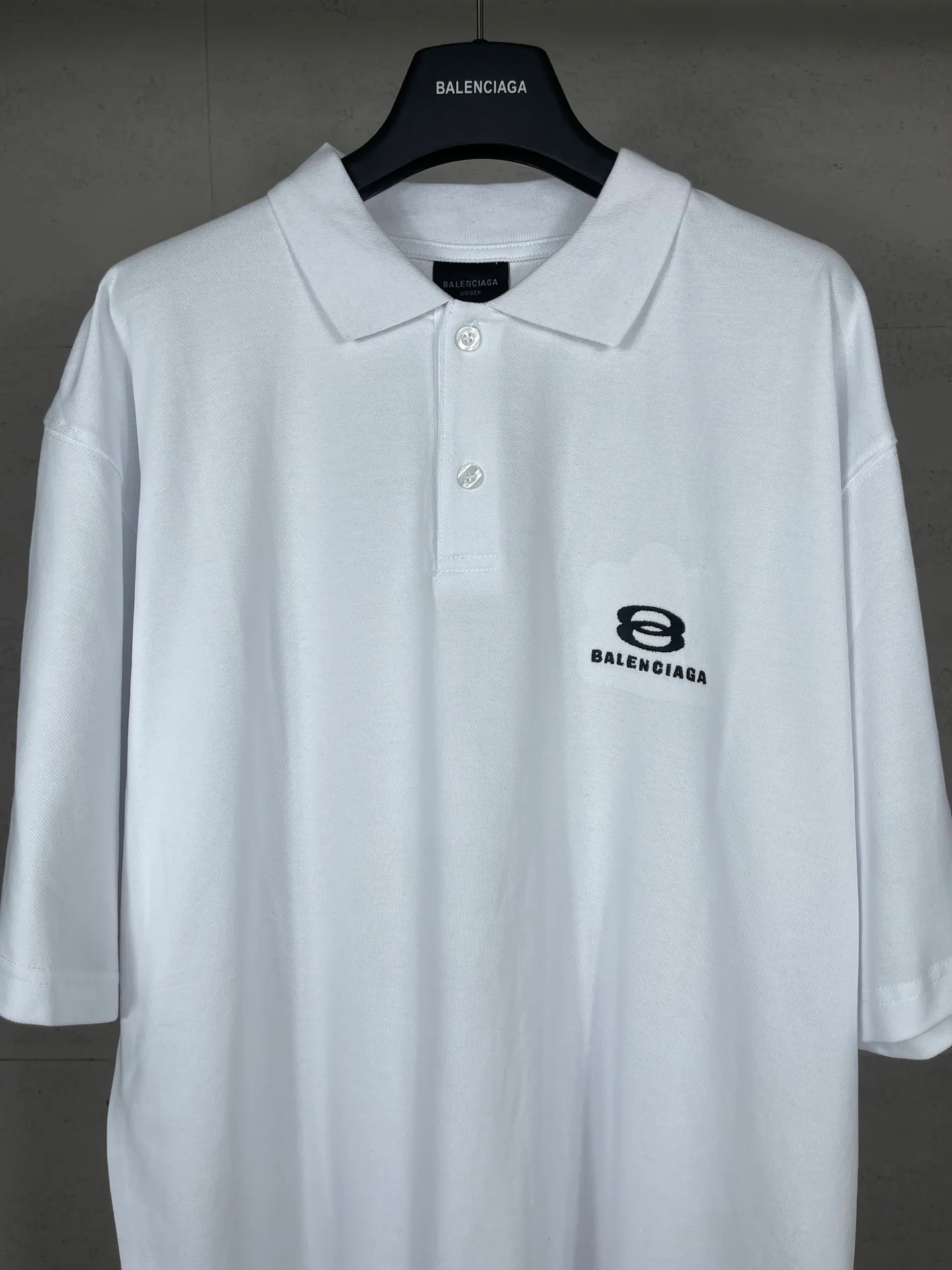 🅿️220 real photos [Top version. Official website quality] BALENCI*GA/Paris #2025 new Paris double-ring classic LOGO embroidered POLO shirt, with front and rear slit design, full of design, welcome to compare. The fabric is made of Paris ZP custom-woven and dyed cotton pique, with a weight of 260 grams. The cloth surface is clean. The cloth pattern is clear, soft and comfortable. The threads are woven and dyed with no color difference. The embroidered LOGO is embroidered using imported Tajima embroidery machine. The effect is three-dimensional. Restore the brick cabinet, adopt OS loose shoulder style. Same style for men and women. Coding: BL252215 Color: black, white Size: XS S M L