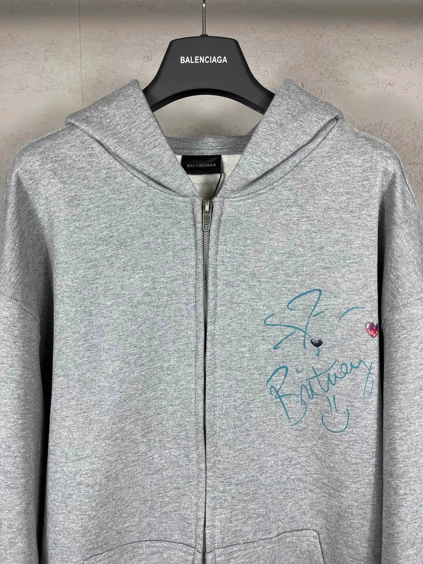 🅿️390 real photos [Top version. Official website quality] BALENCI*GA/26 new model. Balenciaga Music |Britney Series limited edition music collaboration series, front and back direct-print printing, embroidered hat, zipper hooded cardigan and sweatshirt, SS26 latest style. Research and development at the first time, different market currencies. Comparisons welcome. The fabric is made of Paris ZP custom-woven and dyed cotton sweatshirt, with a weight of 460 grams. The cloth surface is clean. The cloth pattern is clear, soft and comfortable. The threads are dyed with no color difference. Printing adopts computer direct printing. The embroidery is done using imported Tajima embroidery machines. Jubie market currency. Welcome to compare. The version adopts OS loose shoulder design. Same style for men and women. Code: BL259958 Color: Gray Size: XS S M L
