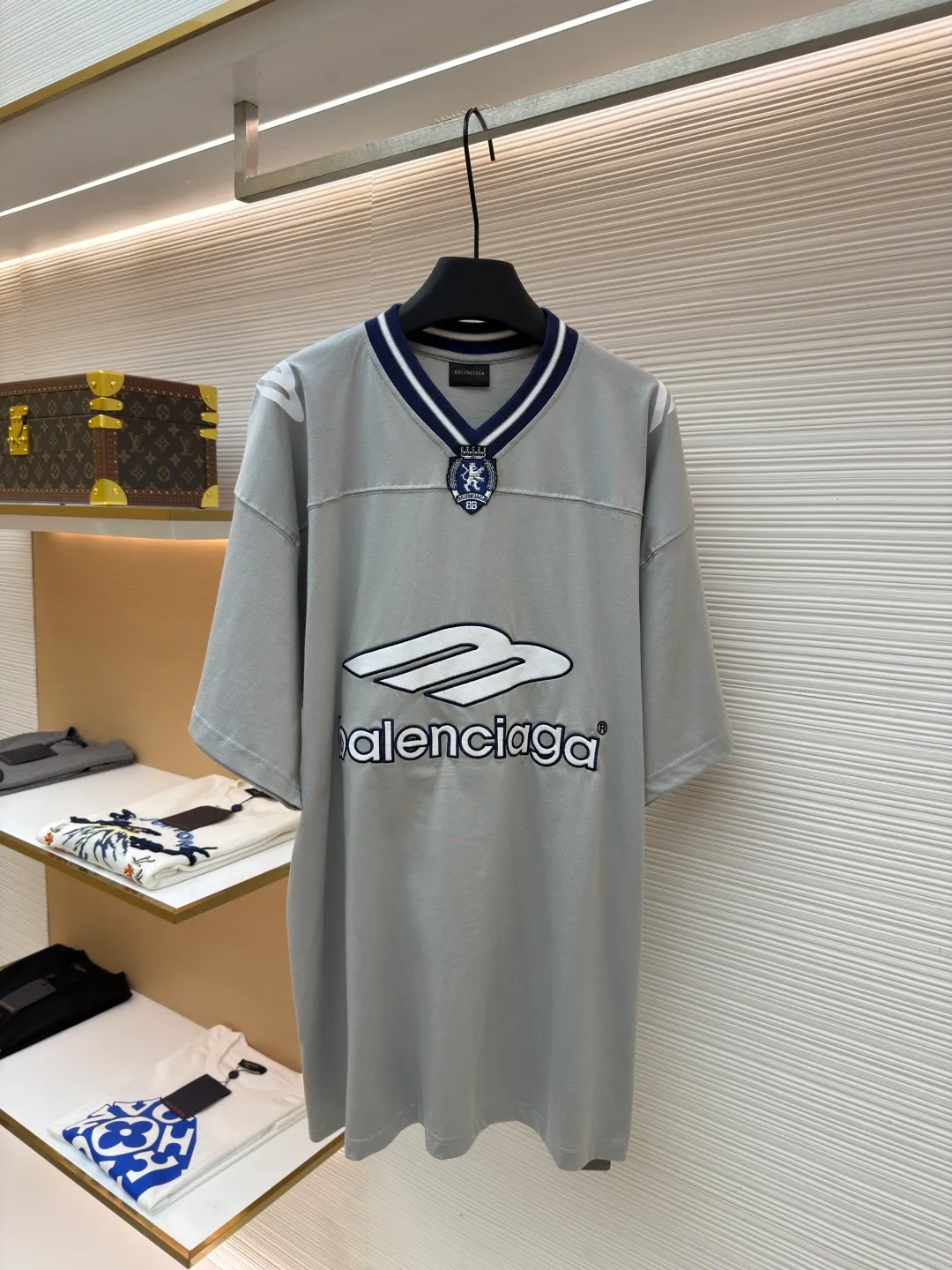 Balenciaga team series V-neck short sleeves ●Original version: Purchased and developed by 4417 ●Item number: 1682335-A60 ●Fabric: plain knitted compact cotton fabric ●Technology: glue printing ●Color: gray ●Version: loose version ●Weight: about 315 grams ●Size: XS-S-M-L ●Description: The main body is made of 24-count special woven compact cotton with a weight of 185g/㎡. Compact spinning technology is applied in the spinning process, which significantly reduces yarn hairiness and makes the yarn smoother and stronger. This gives the fabric an unusually dense structure, a smooth and smooth surface, and excellent pilling resistance, while retaining the softness and breathability of pure cotton. The weight of 185g is light to middleweight, ensuring that the clothing is light, drapeable and can move freely. It is very suitable for creating a long-sleeved shirt that combines sportiness with daily comfort. The V-neck part is made of two different colors of high-elastic rib fabrics. The process step is to first weave ribbed belts of two colors separately, and then through precise cutting and splicing, form a V-shaped neckline with sharp color contrast. It breaks the monotony of the solid color body, uses strong color contrast to create a young and energetic visual focus, and optimizes the neck line. The pattern is pre-cut and formed into patches on fabrics of different materials or colors, and then covered on the body. Finally, high-density embroidery thread is used to fix the edges and outline the internal details. Its function is to create patterns with bright colors, strong texture contrast, three-dimensionality and durability. The edges of the pattern are strong and not easy to wear. A special elastic paste is screen-printed on the sleeves to create brightly colored patterns with a slightly coated feel. The elastic paste ensures that the printed area can stretch with the fabric without cracking. It forms a texture contrast between one flat and one convex with the three-dimensional sense of appliqué, which increases the interest and complexity of the design. The overall wiring is straight and delicate, the fabric is comfortable and soft, and the color is consistent without color difference. It can be matched with the same style to create a fashionable look and control various occasions. Customized accessories, complete with three standards, same style for men and women!