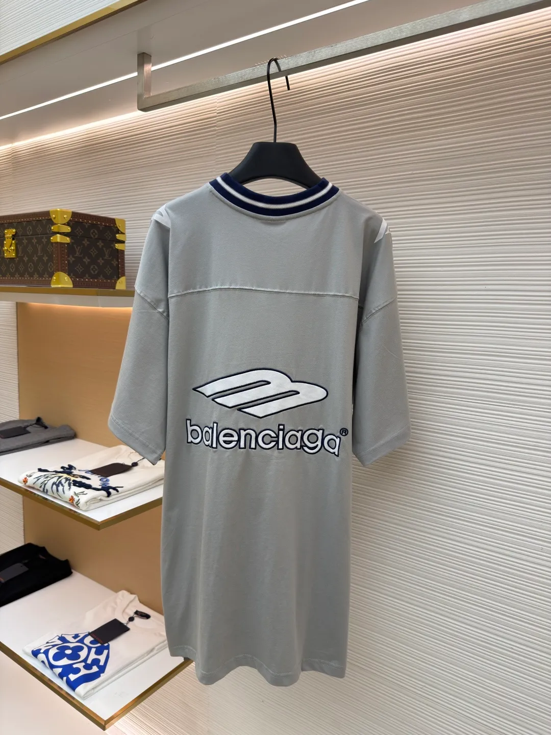 Balenciaga team series V-neck short sleeves ●Original version: Purchased and developed by 4417 ●Item number: 1682335-A60 ●Fabric: plain knitted compact cotton fabric ●Technology: glue printing ●Color: gray ●Version: loose version ●Weight: about 315 grams ●Size: XS-S-M-L ●Description: The main body is made of 24-count special woven compact cotton with a weight of 185g/㎡. Compact spinning technology is applied in the spinning process, which significantly reduces yarn hairiness and makes the yarn smoother and stronger. This gives the fabric an unusually dense structure, a smooth and smooth surface, and excellent pilling resistance, while retaining the softness and breathability of pure cotton. The weight of 185g is light to middleweight, ensuring that the clothing is light, drapeable and can move freely. It is very suitable for creating a long-sleeved shirt that combines sportiness with daily comfort. The V-neck part is made of two different colors of high-elastic rib fabrics. The process step is to first weave ribbed belts of two colors separately, and then through precise cutting and splicing, form a V-shaped neckline with sharp color contrast. It breaks the monotony of the solid color body, uses strong color contrast to create a young and energetic visual focus, and optimizes the neck line. The pattern is pre-cut and formed into patches on fabrics of different materials or colors, and then covered on the body. Finally, high-density embroidery thread is used to fix the edges and outline the internal details. Its function is to create patterns with bright colors, strong texture contrast, three-dimensionality and durability. The edges of the pattern are strong and not easy to wear. A special elastic paste is screen-printed on the sleeves to create brightly colored patterns with a slightly coated feel. The elastic paste ensures that the printed area can stretch with the fabric without cracking. It forms a texture contrast between one flat and one convex with the three-dimensional sense of appliqué, which increases the interest and complexity of the design. The overall wiring is straight and delicate, the fabric is comfortable and soft, and the color is consistent without color difference. It can be matched with the same style to create a fashionable look and control various occasions. Customized accessories, complete with three standards, same style for men and women!
