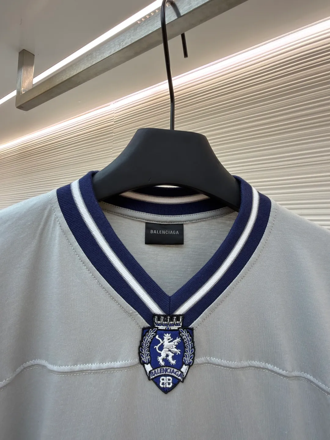 Balenciaga team series V-neck short sleeves ●Original version: Purchased and developed by 4417 ●Item number: 1682335-A60 ●Fabric: plain knitted compact cotton fabric ●Technology: glue printing ●Color: gray ●Version: loose version ●Weight: about 315 grams ●Size: XS-S-M-L ●Description: The main body is made of 24-count special woven compact cotton with a weight of 185g/㎡. Compact spinning technology is applied in the spinning process, which significantly reduces yarn hairiness and makes the yarn smoother and stronger. This gives the fabric an unusually dense structure, a smooth and smooth surface, and excellent pilling resistance, while retaining the softness and breathability of pure cotton. The weight of 185g is light to middleweight, ensuring that the clothing is light, drapeable and can move freely. It is very suitable for creating a long-sleeved shirt that combines sportiness with daily comfort. The V-neck part is made of two different colors of high-elastic rib fabrics. The process step is to first weave ribbed belts of two colors separately, and then through precise cutting and splicing, form a V-shaped neckline with sharp color contrast. It breaks the monotony of the solid color body, uses strong color contrast to create a young and energetic visual focus, and optimizes the neck line. The pattern is pre-cut and formed into patches on fabrics of different materials or colors, and then covered on the body. Finally, high-density embroidery thread is used to fix the edges and outline the internal details. Its function is to create patterns with bright colors, strong texture contrast, three-dimensionality and durability. The edges of the pattern are strong and not easy to wear. A special elastic paste is screen-printed on the sleeves to create brightly colored patterns with a slightly coated feel. The elastic paste ensures that the printed area can stretch with the fabric without cracking. It forms a texture contrast between one flat and one convex with the three-dimensional sense of appliqué, which increases the interest and complexity of the design. The overall wiring is straight and delicate, the fabric is comfortable and soft, and the color is consistent without color difference. It can be matched with the same style to create a fashionable look and control various occasions. Customized accessories, complete with three standards, same style for men and women!