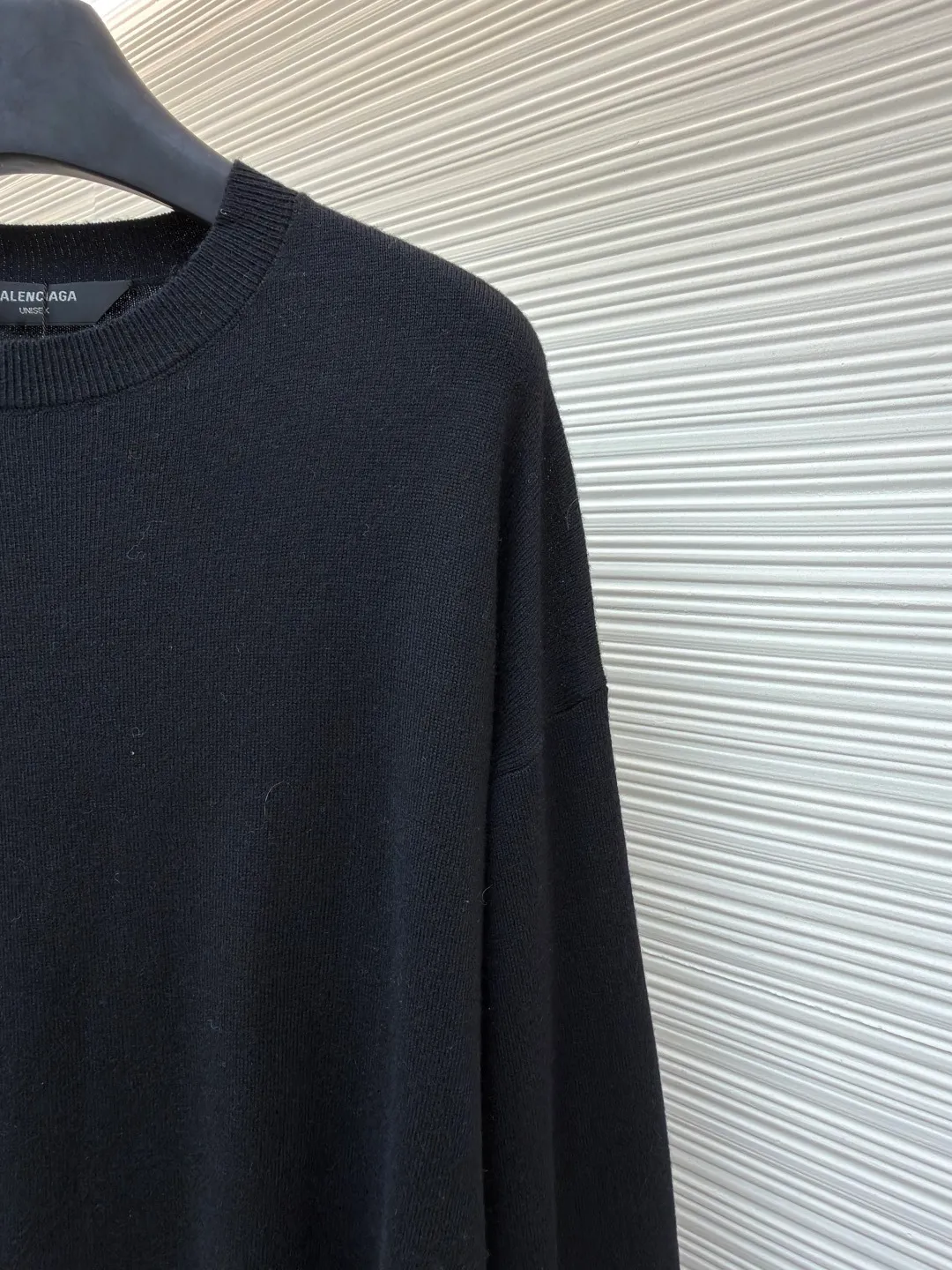 Balenciaga wool blended nameplate crew neck sweater ●Original version: Purchased and developed by 10483 ●Item number: 1681162-A45 ●Fabric: wool blended fabric ●Technology: knitting ●Color: black ●Version: fitted version ●Weight: about 405 grams ●Size: XS-S-M ●Description: High-quality merino wool is selected to provide warmth, softness and elasticity, and mixed with a specific proportion of cashmere to enhance the ultimate skin-friendly touch and luster. In addition, a small amount of synthetic fibers may be added to enhance the durability, anti-wrinkle ability of the sweater and stabilize the silhouette to ensure that the OS version is not easily deformed. Made with a high-needle-count precision knitting machine, the fabric surface is fine and even, and the density is tight, which not only ensures warmth, but also gives the item a high-end texture. This process requires extremely high yarn strength and uniformity. The pattern is carefully calculated and is an architectural, asymmetrical silhouette. The shoulder line is deliberately pulled down, beyond the natural shoulder position, creating a lazy and powerful posture. The depth of the armholes and the ratio of body width to length have been repeatedly considered to ensure that the structure can be kept neat and bloated while showing a loose and flowing drape. Custom molded hardware nameplates, fonts, edge grinding, and surface treatment and aging polishing have all been sampled countless times to achieve the best visual effect and touch. It perfectly embodies the "everyday high fashion" concept advocated by creative director Demna. A basic sweater is transformed into a fashion piece full of attitude and contemporaryity through proportion, top-quality materials and iconic details. It is both suitable for everyday wear and stands out for its strong brand recognition and design. The overall wiring is straight and delicate, the fabric is comfortable and soft, and the color is consistent without color difference. It can be matched with the same style to create a fashionable look and control various occasions. Customized accessories, complete with three standards, same style for men and women!