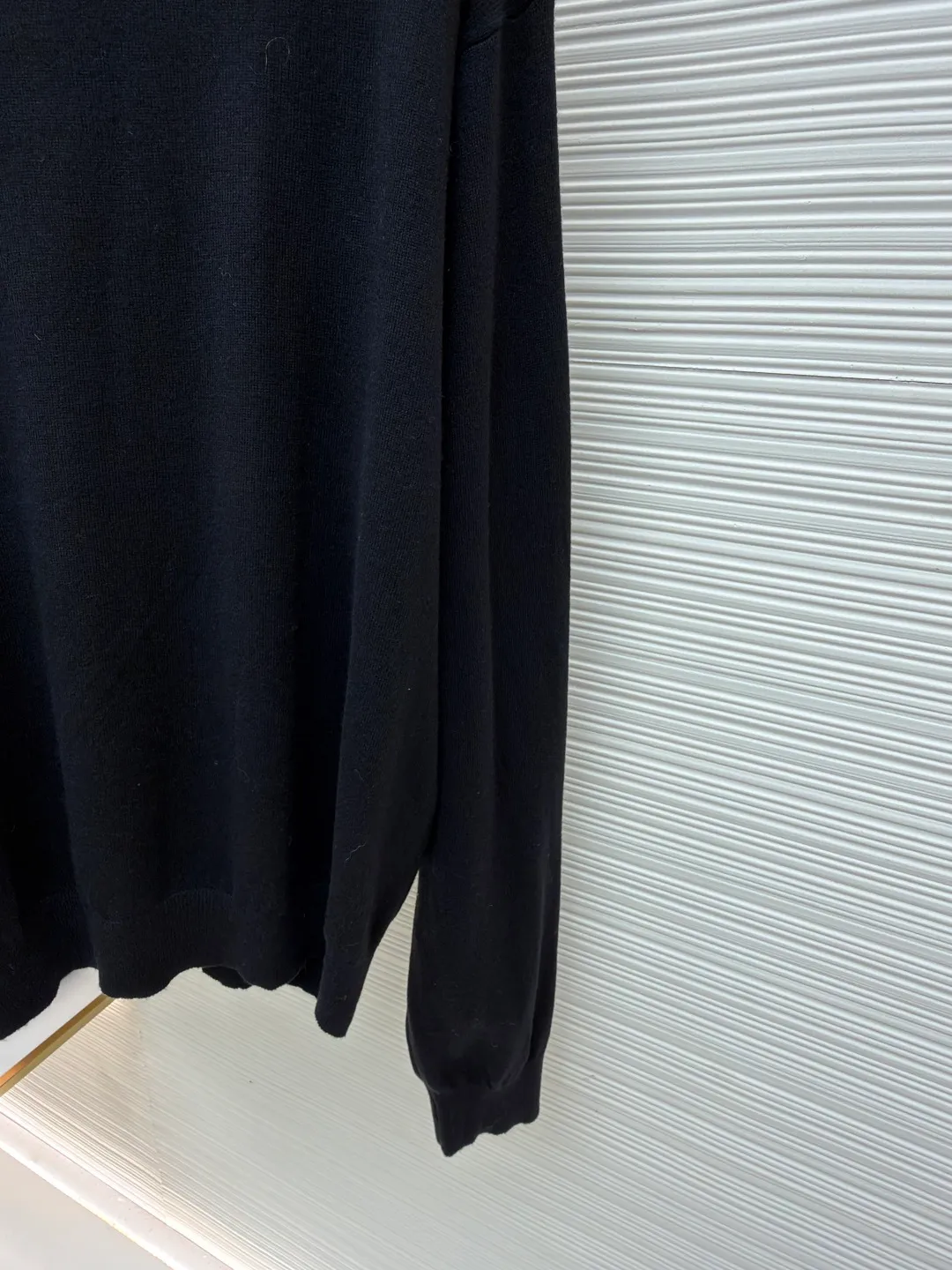 Balenciaga wool blended nameplate crew neck sweater ●Original version: Purchased and developed by 10483 ●Item number: 1681162-A45 ●Fabric: wool blended fabric ●Technology: knitting ●Color: black ●Version: fitted version ●Weight: about 405 grams ●Size: XS-S-M ●Description: High-quality merino wool is selected to provide warmth, softness and elasticity, and mixed with a specific proportion of cashmere to enhance the ultimate skin-friendly touch and luster. In addition, a small amount of synthetic fibers may be added to enhance the durability, anti-wrinkle ability of the sweater and stabilize the silhouette to ensure that the OS version is not easily deformed. Made with a high-needle-count precision knitting machine, the fabric surface is fine and even, and the density is tight, which not only ensures warmth, but also gives the item a high-end texture. This process requires extremely high yarn strength and uniformity. The pattern is carefully calculated and is an architectural, asymmetrical silhouette. The shoulder line is deliberately pulled down, beyond the natural shoulder position, creating a lazy and powerful posture. The depth of the armholes and the ratio of body width to length have been repeatedly considered to ensure that the structure can be kept neat and bloated while showing a loose and flowing drape. Custom molded hardware nameplates, fonts, edge grinding, and surface treatment and aging polishing have all been sampled countless times to achieve the best visual effect and touch. It perfectly embodies the "everyday high fashion" concept advocated by creative director Demna. A basic sweater is transformed into a fashion piece full of attitude and contemporaryity through proportion, top-quality materials and iconic details. It is both suitable for everyday wear and stands out for its strong brand recognition and design. The overall wiring is straight and delicate, the fabric is comfortable and soft, and the color is consistent without color difference. It can be matched with the same style to create a fashionable look and control various occasions. Customized accessories, complete with three standards, same style for men and women!