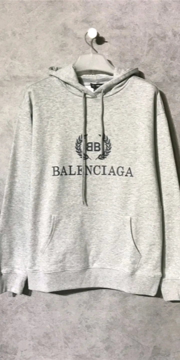 Real shot of the video - the top tested version of Balenciaga's classic wheat ear hooded sweatshirt. It is made of 480g pure cotton double-yarn terry fabric, which is thick and textured. It is made of high-density knitted fabric technology. It is firm and elastic, with high suppleness and skin-friendliness. It feels soft and delicate, does not shrink or deform, and has a crisp and stylish upper body. It is different from the cheap soft sofa fabrics with low weight and low count on the market.  Ultra-high-level workmanship, every detail shows a sense of luxury, and the original three-dimensional cutting process creates a perfect fit. The OS loose shoulder style accommodates all body types. It is a truly versatile style that looks slim and good-looking for both men and women.  The brushed classic wheat ear letter print has high fastness and will not crack or fall off. The classic pattern will never go out of style. Multiple colors are available, and every color is beautiful!  Color: Gray Size: XS-L P:420