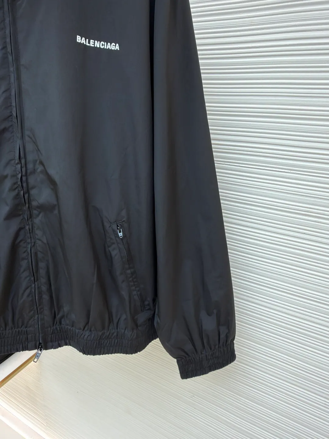 Balenciaga stand collar logo embroidered quick-drying jacket ●Original version: purchased and developed by 10128 ●Item number: 1681403-B40 ●Fabric: Satin blended fabric ●Technology: embroidery production ●Color: black ●Version: Loose fit ●Weight: about 380 grams ●Size: 36-38-40-42 ●Description: This jacket is made of high-quality windproof fabric, with a crisp texture and good breathability. The stand-up collar design fits the neck and is windproof and neat. The brand letters on the back adopt three-dimensional embroidery technology, the stitches are even and full, and the letter shape is three-dimensional and layered, making it highly recognizable. The body is cut in a loose fit with smooth and natural lines, making it comfortable and casual to wear. The ribbed design on the cuffs and hem has excellent elasticity, fits the body shape, and is windproof and warm. The zipper is smooth and durable, and harmonizes with the overall style. From fabric selection to embroidery craftsmanship to rib processing in details, every step reflects the brand's rigorous control of craftsmanship, not only showing a sense of street fashion, but also ensuring practicality and quality through exquisite craftsmanship. The overall wiring is straight and delicate, the fabric is comfortable and soft, and the color is consistent without color difference. It can be matched with the same style to create a fashionable look, and can be used in various occasions. Customized accessories, complete with three standards, the same style for men and women.