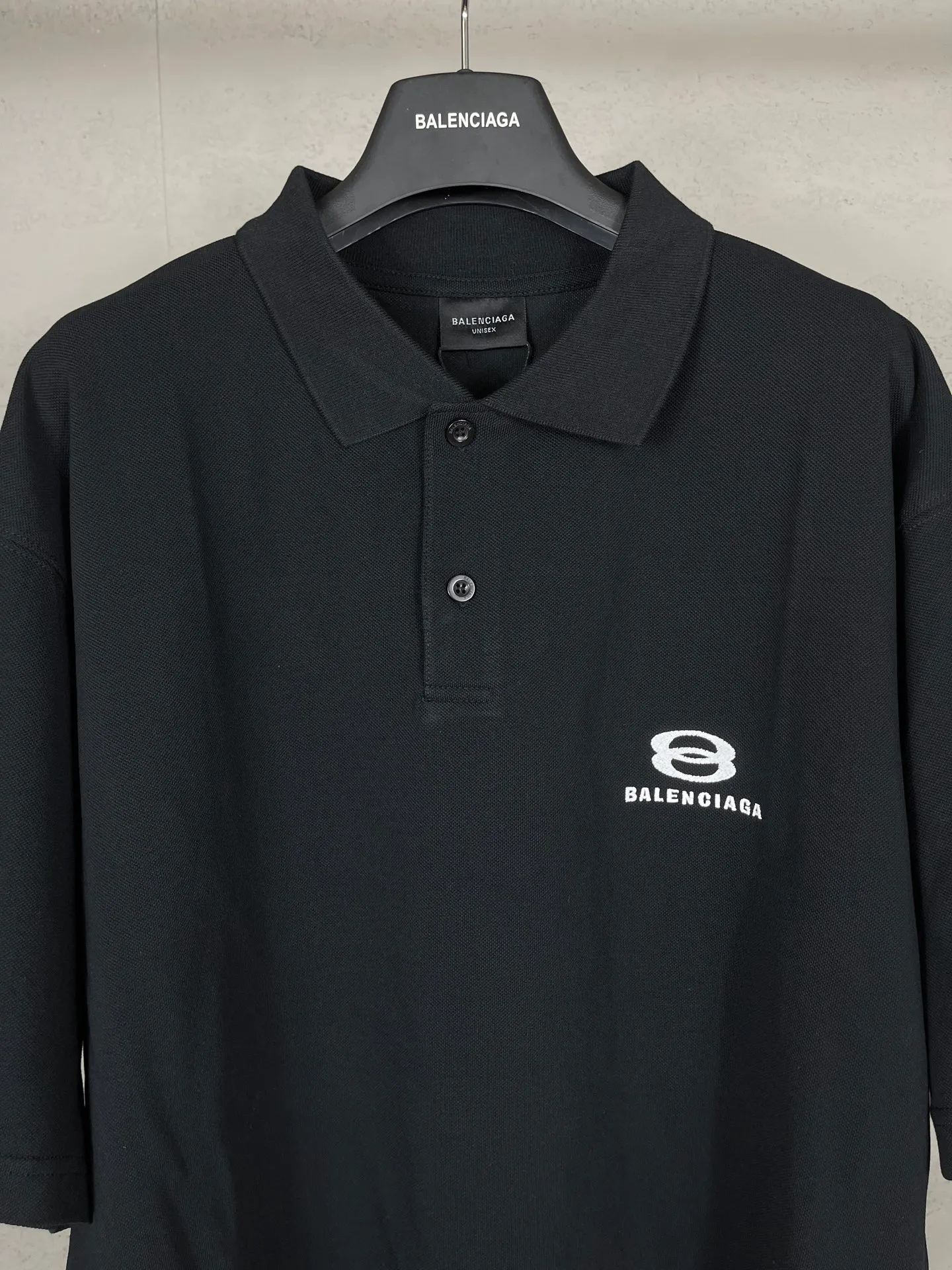 🅿️220 real photos [Top version. Official website quality] BALENCI*GA/Paris #2025 new Paris double-ring classic LOGO embroidered POLO shirt, with front and rear slit design, full of design, welcome to compare. The fabric is made of Paris ZP custom-woven and dyed cotton pique, with a weight of 260 grams. The cloth surface is clean. The cloth pattern is clear, soft and comfortable. The threads are woven and dyed with no color difference. The embroidered LOGO is embroidered using imported Tajima embroidery machine. The effect is three-dimensional. Restore the brick cabinet, adopt OS loose shoulder style. Same style for men and women. Coding: BL252215 Color: black, white Size: XS S M L