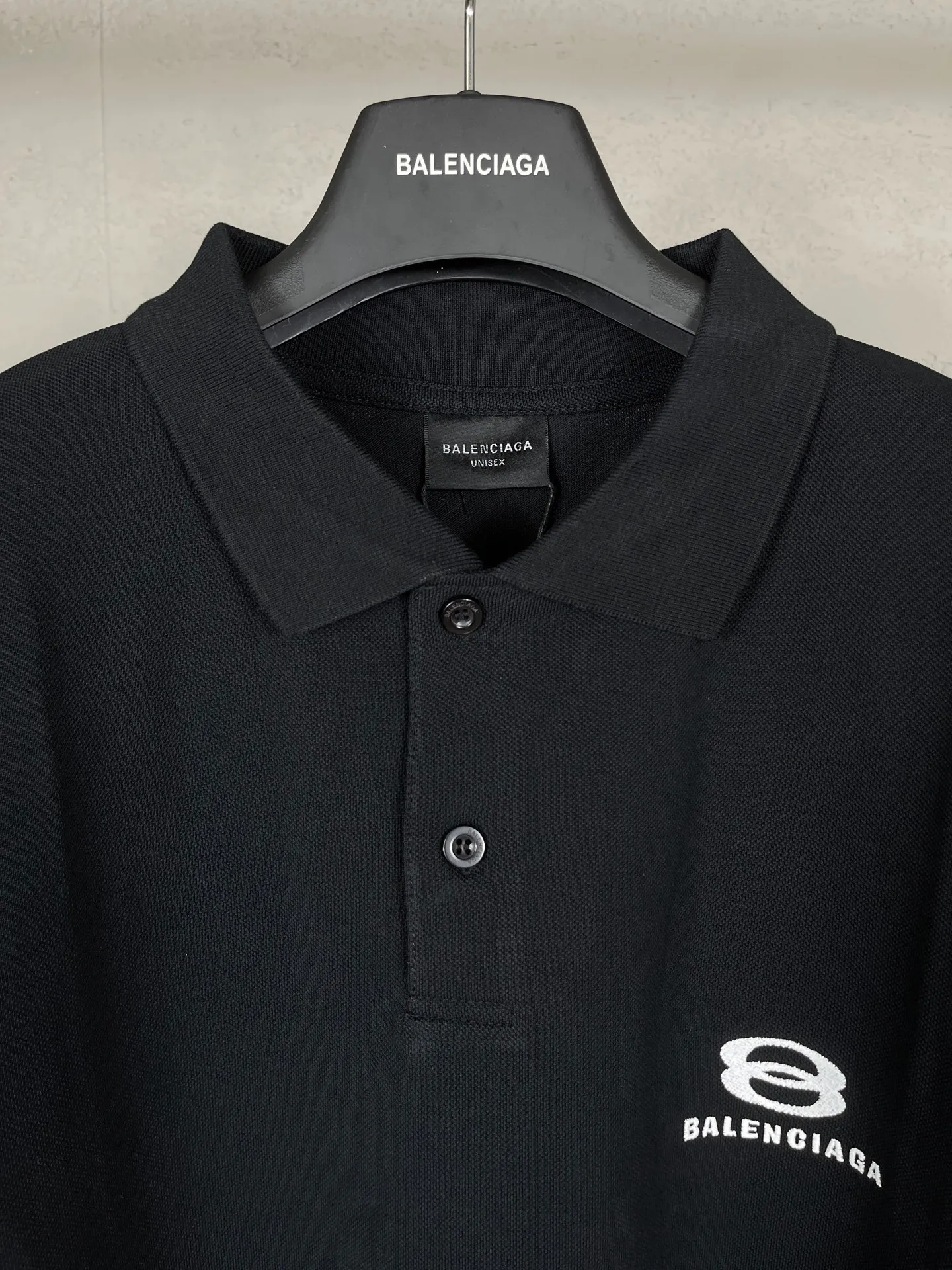 🅿️220 real photos [Top version. Official website quality] BALENCI*GA/Paris #2025 new Paris double-ring classic LOGO embroidered POLO shirt, with front and rear slit design, full of design, welcome to compare. The fabric is made of Paris ZP custom-woven and dyed cotton pique, with a weight of 260 grams. The cloth surface is clean. The cloth pattern is clear, soft and comfortable. The threads are woven and dyed with no color difference. The embroidered LOGO is embroidered using imported Tajima embroidery machine. The effect is three-dimensional. Restore the brick cabinet, adopt OS loose shoulder style. Same style for men and women. Coding: BL252215 Color: black, white Size: XS S M L