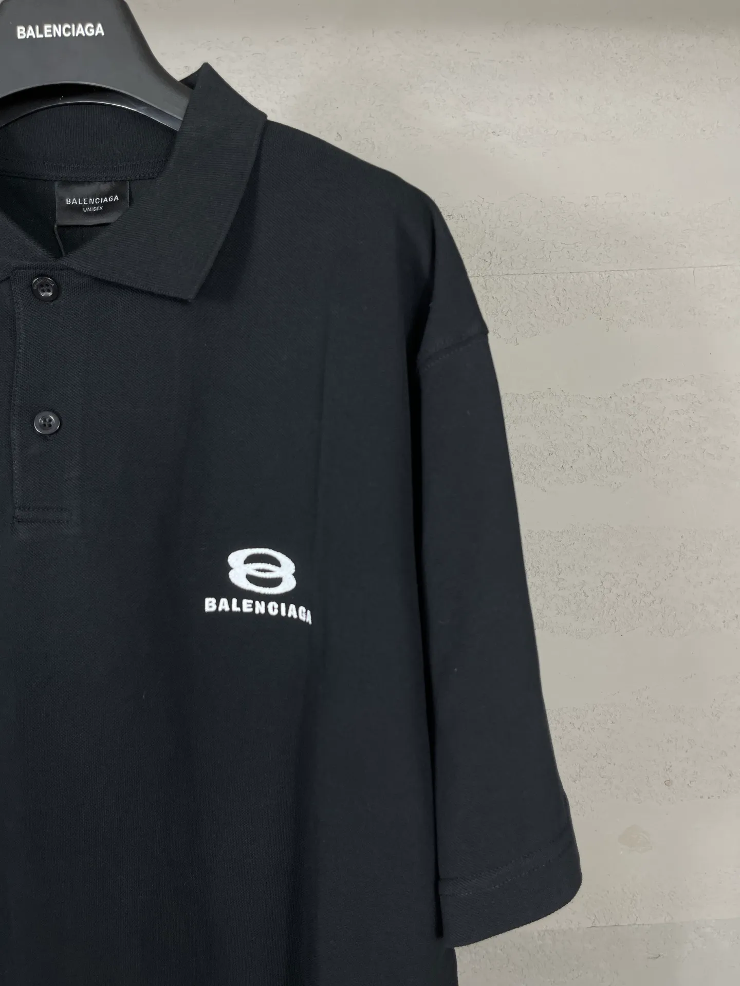 🅿️220 real photos [Top version. Official website quality] BALENCI*GA/Paris #2025 new Paris double-ring classic LOGO embroidered POLO shirt, with front and rear slit design, full of design, welcome to compare. The fabric is made of Paris ZP custom-woven and dyed cotton pique, with a weight of 260 grams. The cloth surface is clean. The cloth pattern is clear, soft and comfortable. The threads are woven and dyed with no color difference. The embroidered LOGO is embroidered using imported Tajima embroidery machine. The effect is three-dimensional. Restore the brick cabinet, adopt OS loose shoulder style. Same style for men and women. Coding: BL252215 Color: black, white Size: XS S M L