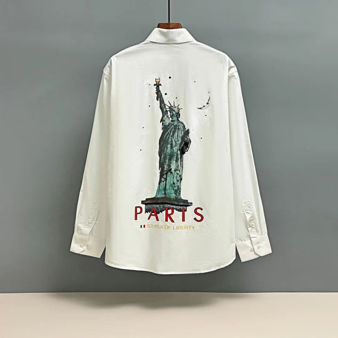 🅿️220 BALENCIAGA/Balenciaga early autumn printed embroidered shirt. Customized classic 40-count plain weave imitation Tencel Paris shirt fabric. Loose fit and three-dimensional upper body. Smooth and natural lines from shoulder line to waistline to hem. Smooth transition of lines. No unnecessary folds or accumulation. The whole body is neat and stretched. Customized Paris logo engraved buttons. Embroidery of Paris letters on the chest. Precise stitching. Silky threading. Paired with large-area printing of the Statue of Liberty on the back. The effect is three-dimensional. The printing fits perfectly with the fabric, and there will be no problems such as color fading, peeling off, etc. Size: S M L XL