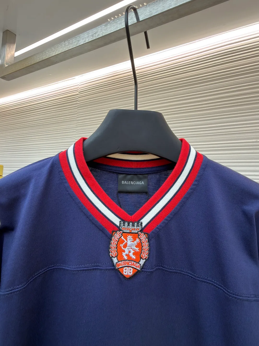 Balenciaga team series V-neck long sleeves ●Original version: purchased and developed by 8016 ●Item number: 1682072-A55 ●Fabric: plain knitted compact cotton fabric ●Technology: glue printing ●Color: blue ●Version: loose version ●Weight: about 375 grams ●Size: XS-S-M-L ●Description: The main body is made of 24-count special woven compact cotton with a weight of 185g/㎡. Compact spinning technology is applied in the spinning process, which significantly reduces yarn hairiness and makes the yarn smoother and stronger. This gives the fabric an unusually dense structure, a smooth and smooth surface, and excellent pilling resistance, while retaining the softness and breathability of pure cotton. The weight of 185g is light to middleweight, ensuring that the clothing is light, drapeable and can move freely. It is very suitable for creating a long-sleeved shirt that combines sportiness with daily comfort. The V-neck part is made of two different colors of high-elastic rib fabrics. The process step is to first weave ribbed belts of two colors separately, and then through precise cutting and splicing, form a V-shaped neckline with sharp color contrast. It breaks the monotony of the solid color body, uses strong color contrast to create a young and energetic visual focus, and optimizes the neck line. The pattern is pre-cut and formed into patches on fabrics of different materials or colors, and then covered on the body. Finally, high-density embroidery thread is used to fix the edges and outline the internal details. Its function is to create patterns with bright colors, strong texture contrast, three-dimensionality and durability. The edges of the pattern are strong and not easy to wear. A special elastic paste is screen-printed on the sleeves to create brightly colored patterns with a slightly coated feel. The elastic paste ensures that the printed area can stretch with the fabric without cracking. It forms a texture contrast between one flat and one convex with the three-dimensional sense of appliqué, which increases the interest and complexity of the design. The overall wiring is straight and delicate, the fabric is comfortable and soft, and the color is consistent without color difference. It can be matched with the same style to create a fashionable look and control various occasions. Customized accessories, complete with three standards, same style for men and women!