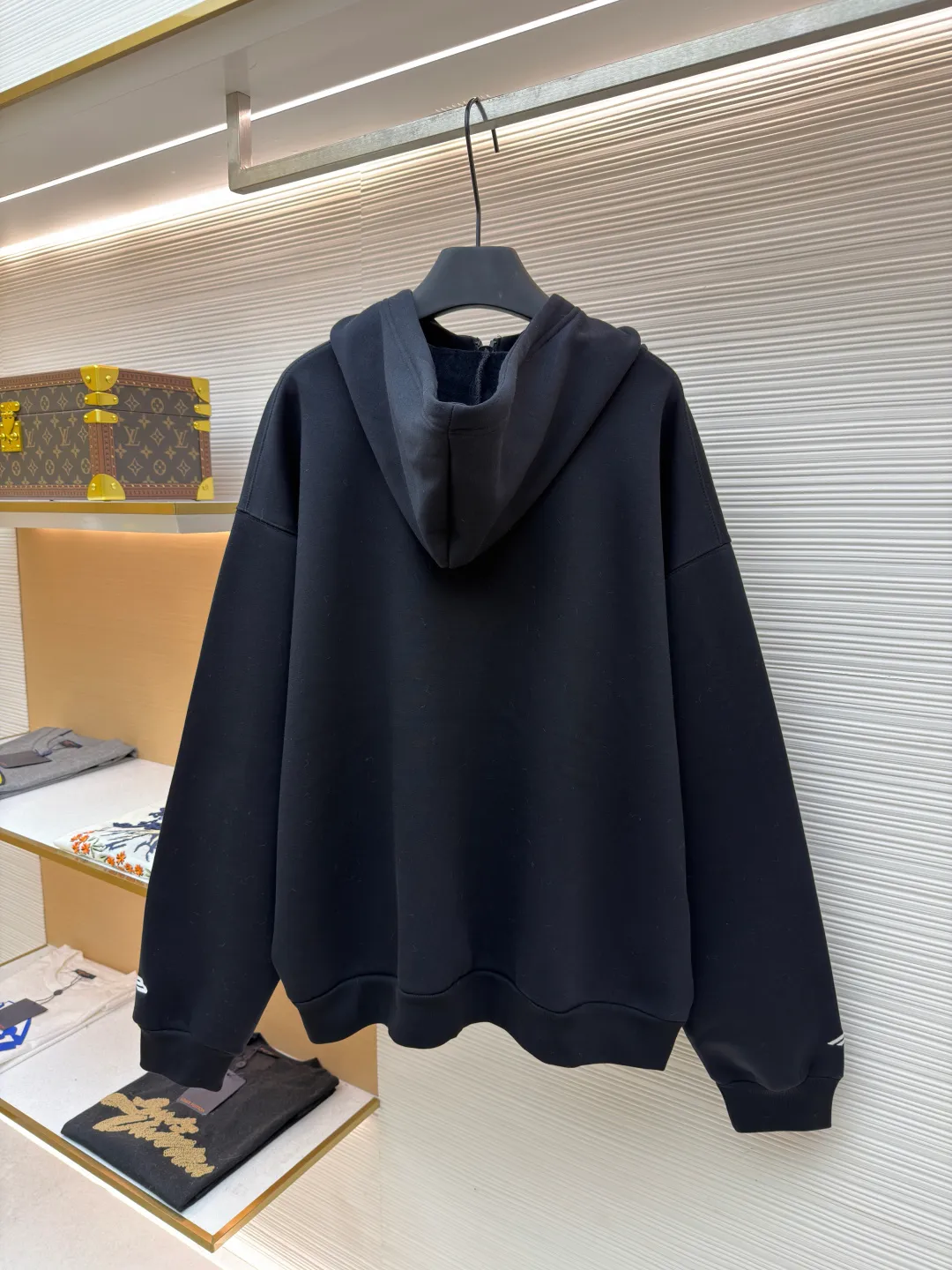 Balenciaga SIK WEAR ski series velvet hooded sweatshirt ●Original version: purchased and developed for 9999 ●Item number: 1681932-B15 ●Fabric: velvet fabric ●Technology: embroidery production ●Color: black ●Version: loose fit ●Weight: about 945 grams ●Size: XS-S-M-L ●Description: It adopts a high-count and high-density plain knitting structure. The surface shows an extremely delicate and smooth texture, giving the garment a low-key and high-end matte texture. This is in sharp contrast to traditional heavy and fluffy ski suits, achieving a balance between "light weight" and "excellent performance." After being treated with Teflon coating, the surface of the fabric can resist being soaked by snow water, while maintaining a certain degree of breathability to avoid accumulation of sweat inside. The fabric may also be tear-resistant and have some elasticity to ensure freedom of movement and durability during skiing. The interior is made of velvet material. By creating a large number of tiny air traps on its surface, a layer of still air is formed, which effectively locks body heat and achieves excellent warmth retention. The materials selected focus on skin-friendly feeling to avoid the itching that may be caused by ordinary thermal insulation materials. At the same time, excellent fleece has quick-drying properties, which can quickly export internal moisture to the outer layer for evaporation, keeping the skin dry and comfortable. It is perfect for the micro-environment of alternating hot and cold conditions when skiing. Zippers are not commercially available, but "customized rubber zippers" specially developed for the SIKWEAR series. Its teeth are treated with high-performance polymer or rubber to ensure they are smooth and durable in extremely cold environments and are not easy to freeze. The design of the zipper puller must also be ergonomically considered to facilitate operation when wearing gloves. Customized jacquard webbing, jacquard weaving technology can create clear, three-dimensional and never fall off patterns, its texture and firmness are far better than ordinary printing. This webbing becomes the main visual axis that runs through the front of the garment, making it highly recognizable. The letters are finished with Tajima embroidery. The effect is far superior to ordinary computer embroidery. It is characterized by extremely dense and even stitches, clear and sharp edges, and full and three-dimensional patterns. The direction and tension of each stitch are precisely controlled to ensure that the logo remains in perfect shape under any wearing condition and will not wrinkle or deform. The rich texture and luster brought about by this craftsmanship are core expressions of luxury identity. SIKWEAR velvet hooded sweatshirt is a piece of clothing art that integrates cutting-edge technological fabrics, sophisticated functional design, luxurious custom details and palace-level craftsmanship. It breaks the boundaries between professional ski wear and everyday fashion, creating a complete narrative about modern luxury sportswear. It's more than just a sweatshirt for keeping warm, it's a piece of equipment for connoisseurs who pursue ultimate performance and top-notch fashion. The overall wiring is straight and delicate, the fabric is comfortable and soft, and the color is consistent without color difference. It can be matched with the same style to create a fashionable look and control various occasions. Customized accessories, complete with three standards, same style for men and women!