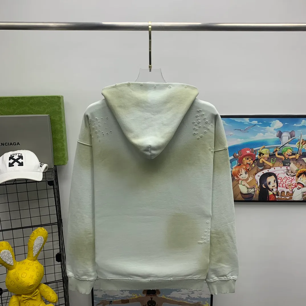 Top tested version 23FW BALENCIAGA Paris Manchester United limited edition distressed male and female couple star same style pure cotton loose hooded sweatshirt [very suitable for Douyin, and other platforms! The letters in the LOGO position have been damaged and polished! 】 The fabric is custom-made washed knitted cotton terry material. The upper body is very soft. The front panel uses a classic hand pocket with a worn effect. The overall yellow and dirty effect is all artificially sprayed with majolica. It requires proficiency and experience to achieve this natural and elegant effect!  Customized towel embroidery on the chest, heavily damaged! The aging effect is very obvious! The overall artificial positioning coating is hand-made, washed and dirty. The frayed hole craftsmanship has a hand-painted graffiti effect. The arms behind the bend are made of open-stitch frayed craftsmanship. The wiring is delicate. Elastic cuff design. The whole body is hand-positioned with muddy dyeing and frayed effect! Ready-made garments are washed twice with water +➕ once with wax. It feels smooth!   The Manchester United letters and logo on the chest are designed with full embroidery and the details are visible!  Size: XS-L Color: White Black P: 470