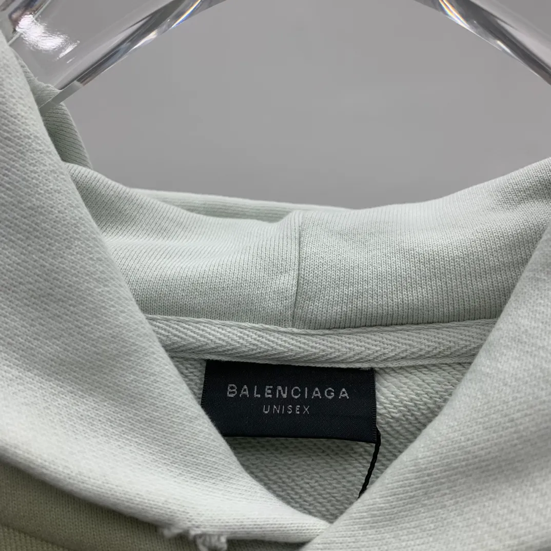 Top tested version 23FW BALENCIAGA Paris Manchester United limited edition distressed male and female couple star same style pure cotton loose hooded sweatshirt [very suitable for Douyin, and other platforms! The letters in the LOGO position have been damaged and polished! 】 The fabric is custom-made washed knitted cotton terry material. The upper body is very soft. The front panel uses a classic hand pocket with a worn effect. The overall yellow and dirty effect is all artificially sprayed with majolica. It requires proficiency and experience to achieve this natural and elegant effect!  Customized towel embroidery on the chest, heavily damaged! The aging effect is very obvious! The overall artificial positioning coating is hand-made, washed and dirty. The frayed hole craftsmanship has a hand-painted graffiti effect. The arms behind the bend are made of open-stitch frayed craftsmanship. The wiring is delicate. Elastic cuff design. The whole body is hand-positioned with muddy dyeing and frayed effect! Ready-made garments are washed twice with water +➕ once with wax. It feels smooth!   The Manchester United letters and logo on the chest are designed with full embroidery and the details are visible!  Size: XS-L Color: White Black P: 470