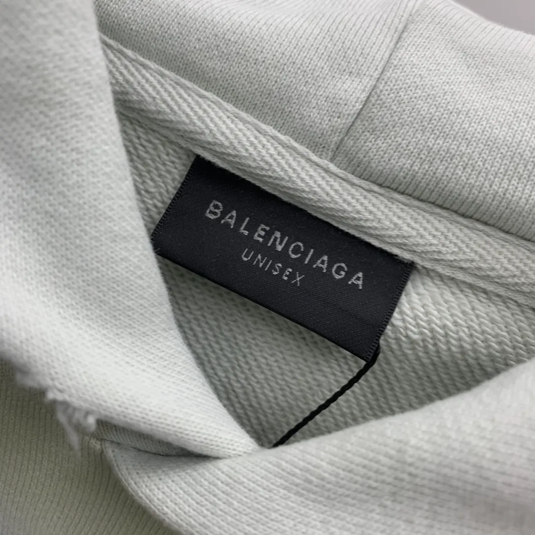 Top tested version 23FW BALENCIAGA Paris Manchester United limited edition distressed male and female couple star same style pure cotton loose hooded sweatshirt [very suitable for Douyin, and other platforms! The letters in the LOGO position have been damaged and polished! 】 The fabric is custom-made washed knitted cotton terry material. The upper body is very soft. The front panel uses a classic hand pocket with a worn effect. The overall yellow and dirty effect is all artificially sprayed with majolica. It requires proficiency and experience to achieve this natural and elegant effect!  Customized towel embroidery on the chest, heavily damaged! The aging effect is very obvious! The overall artificial positioning coating is hand-made, washed and dirty. The frayed hole craftsmanship has a hand-painted graffiti effect. The arms behind the bend are made of open-stitch frayed craftsmanship. The wiring is delicate. Elastic cuff design. The whole body is hand-positioned with muddy dyeing and frayed effect! Ready-made garments are washed twice with water +➕ once with wax. It feels smooth!   The Manchester United letters and logo on the chest are designed with full embroidery and the details are visible!  Size: XS-L Color: White Black P: 470