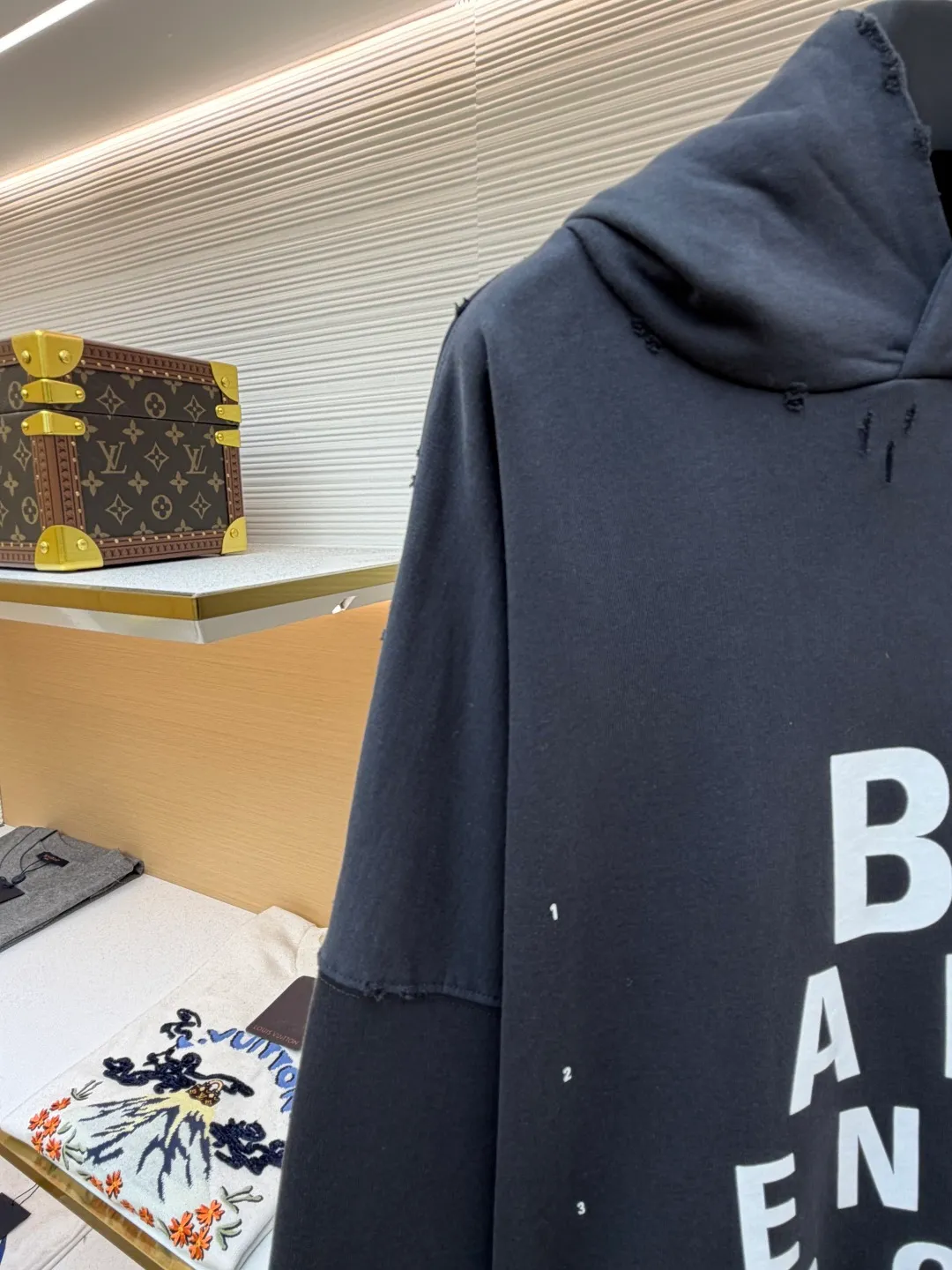 Balenciaga hooded letter printed loose long-sleeved sweatshirt ●Original version: Purchased and developed by 3889 ●Item number: 1681887-B05 ●Fabric: combed cotton terry gray sweatshirt fabric ●Technology: Glue printing production ●Color: gray ●Version: loose fit ●Weight: about 1090 grams ●Size: S-M-L ●Description: The fabric is made of heavy fleece cotton, which has been washed and distressed. The surface shows a natural frayed texture, taking into account softness and an old retro feel. The collar, cuffs and other parts have been hand-edged, so that the rough edges have a uniform texture and are not off-line. The pattern adopts a high-density glue printing process: letters and logos are printed in layers, and the thickness of the glue is even. The white printing appears clearly on the dark gray background. It has been tested for durability and will not easily crack and fall off after repeated washing. It is cut in a loose, dropped-shoulder style, with a hood and no drawstring design. The edge of the hood is reinforced with double-needle sewing. The kangaroo pocket is an embedded structure, and the edge of the opening is hand-stitched. The inside is lined with lining to prevent deformation. The cuffs and hem are ribbed with the same fabric, which has moderate elasticity and is not easy to loosen. The overall craftsmanship highlights the brand's iconic "destruction aesthetics" style. The overall wiring is straight and delicate, the fabric is comfortable and soft, and the color is consistent without color difference. It can be matched with the same style to create a fashionable look and control various occasions. Customized accessories, complete with three standards, same style for men and women!