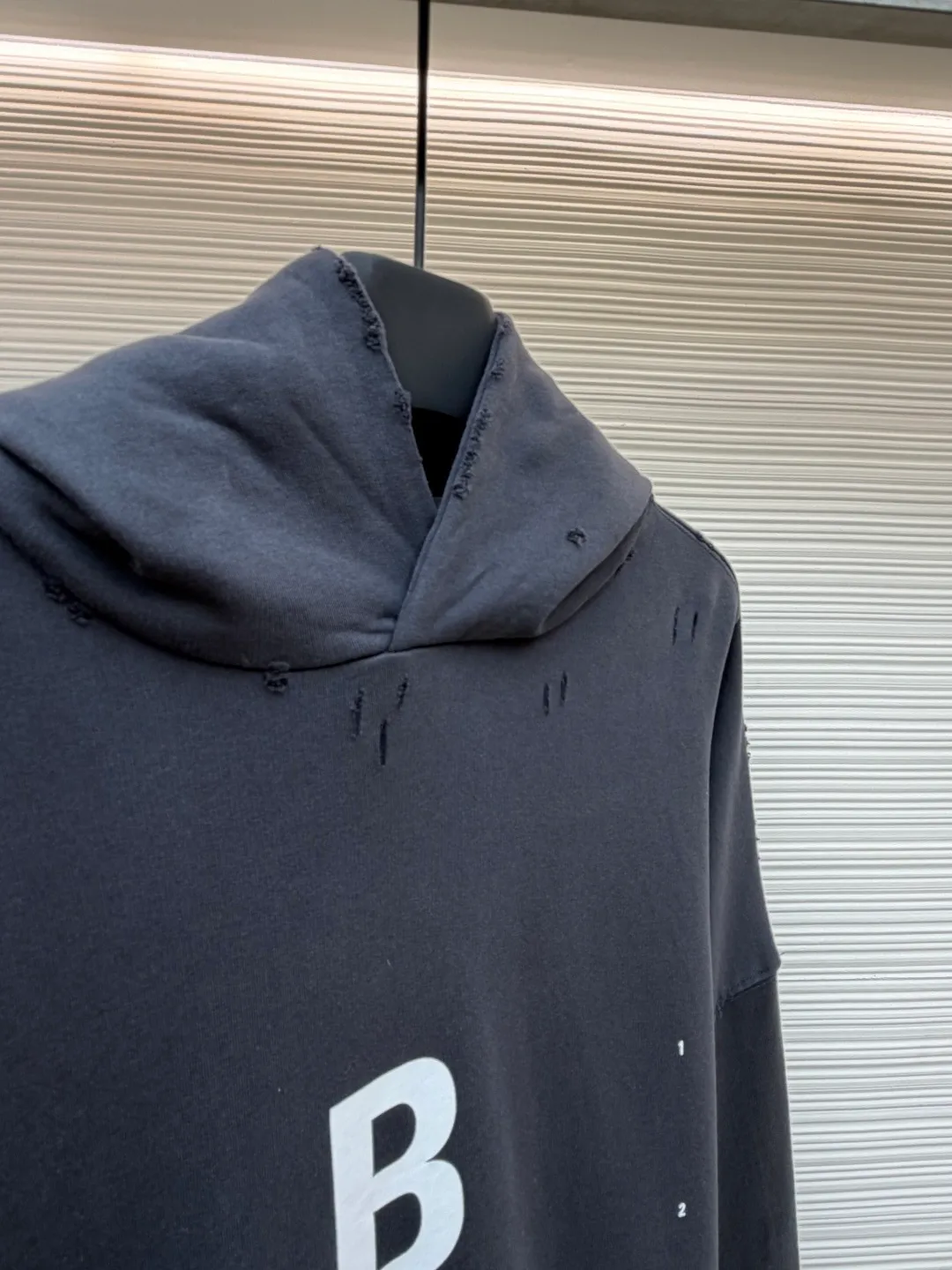 Balenciaga hooded letter printed loose long-sleeved sweatshirt ●Original version: Purchased and developed by 3889 ●Item number: 1681887-B05 ●Fabric: combed cotton terry gray sweatshirt fabric ●Technology: Glue printing production ●Color: gray ●Version: loose fit ●Weight: about 1090 grams ●Size: S-M-L ●Description: The fabric is made of heavy fleece cotton, which has been washed and distressed. The surface shows a natural frayed texture, taking into account softness and an old retro feel. The collar, cuffs and other parts have been hand-edged, so that the rough edges have a uniform texture and are not off-line. The pattern adopts a high-density glue printing process: letters and logos are printed in layers, and the thickness of the glue is even. The white printing appears clearly on the dark gray background. It has been tested for durability and will not easily crack and fall off after repeated washing. It is cut in a loose, dropped-shoulder style, with a hood and no drawstring design. The edge of the hood is reinforced with double-needle sewing. The kangaroo pocket is an embedded structure, and the edge of the opening is hand-stitched. The inside is lined with lining to prevent deformation. The cuffs and hem are ribbed with the same fabric, which has moderate elasticity and is not easy to loosen. The overall craftsmanship highlights the brand's iconic "destruction aesthetics" style. The overall wiring is straight and delicate, the fabric is comfortable and soft, and the color is consistent without color difference. It can be matched with the same style to create a fashionable look and control various occasions. Customized accessories, complete with three standards, same style for men and women!
