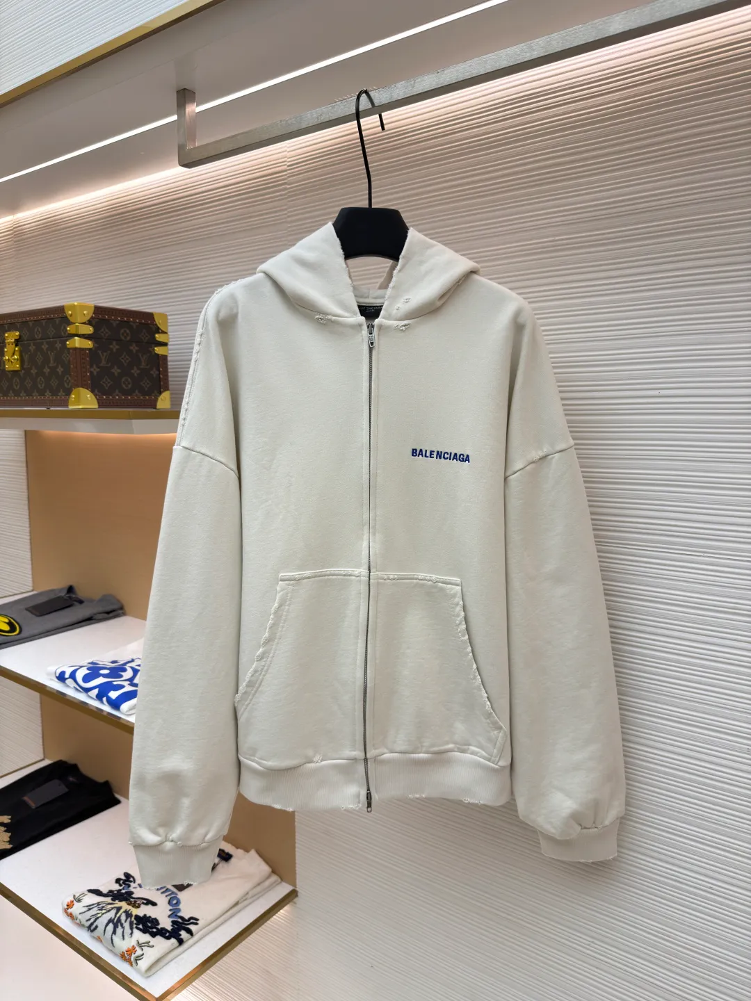Balenciaga letter embroidered hooded zipper long-sleeved sweatshirt ●Original version: Purchased and developed for 9200 ●Item number: 1682263-A95 ●Fabric: combed cotton ●Technology: Washed and frayed ●Color: white ●Version: loose fit ●Weight: about 965 grams ●Size: S-M-L ●Description: This Balenciaga letter embroidered hooded zipper sweatshirt is made of 380g heavyweight pure cotton terry cloth, which has been treated with enzyme washing process. The fabric has a natural old-fashioned soft and waxy texture. At the same time, the stone grinding process is used to create irregular raw edge effects on the cuffs and hem, restoring the retro street style. The body adopts a loose, dropped-shoulder version, and the three-dimensional tailoring makes the shoulder lines smooth. The hooded part has a built-in drawstring made of pure cotton and is pre-shrunk to prevent it from deforming. The custom-made metal zipper on the front zipper closes smoothly and has no lag after repeated opening and closing tests. The brand letters on the left chest are made with imported embroidery machines using flat embroidery stitches, using polyester thread with high color fastness. The stitches are fine and neat without skipping, and the letter outline is three-dimensional and clear. The overall stitching uses double-needle overlocking technology, with up to 12 stitches per inch. The ribbed edges on the cuffs and hem are made of spandex blended material, which has long-lasting elasticity and is not easy to loosen, taking into account both wearing comfort and stiffness. The overall wiring is straight and delicate, the fabric is comfortable and soft, and the color is consistent without color difference. It can be matched with the same style to create a fashionable look and control various occasions. Customized accessories, complete with three standards, same style for men and women!