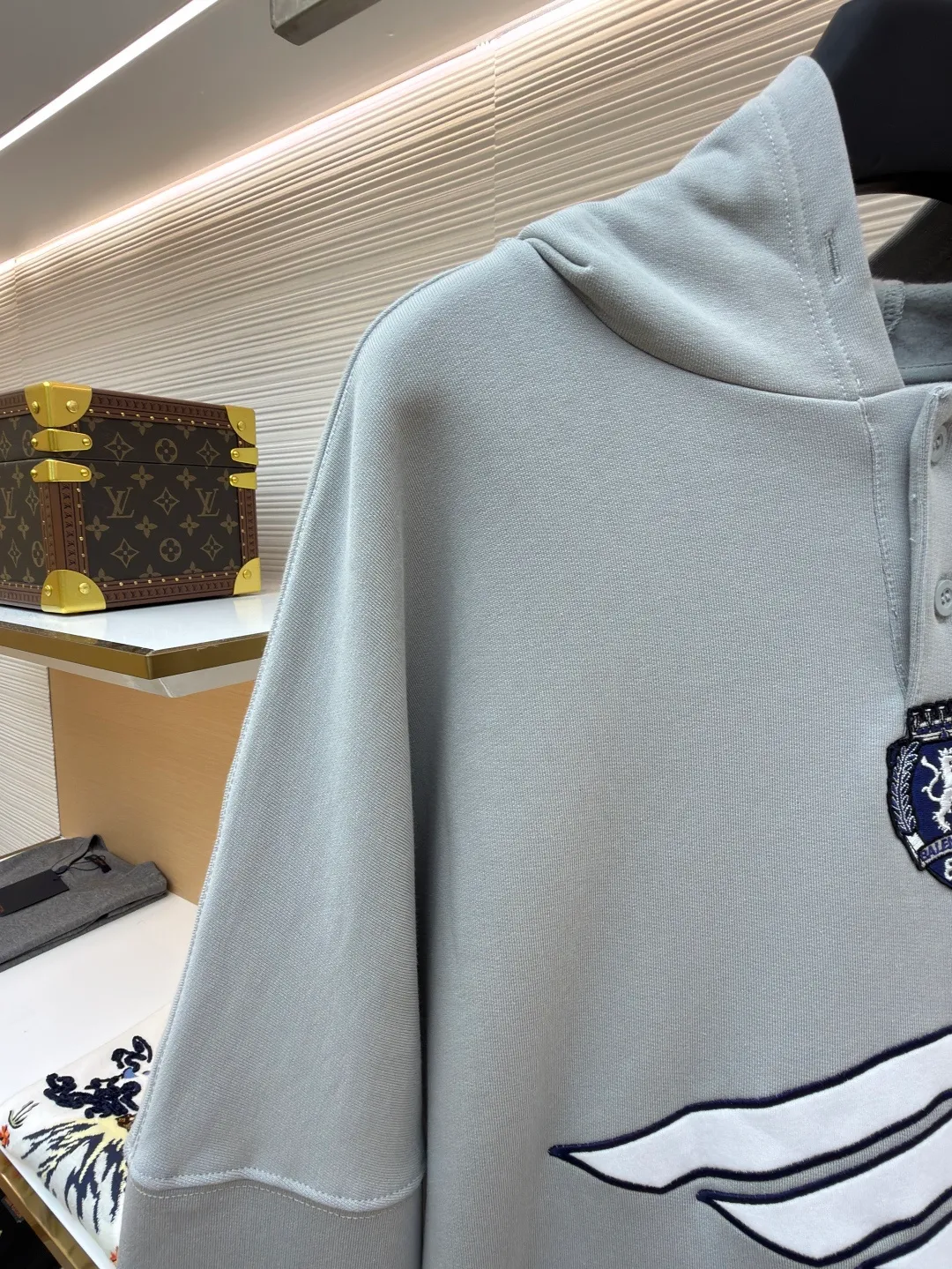 Balenciaga 3B football Polo hoodie ●Original version: purchased and developed by 10767 ●Item number: 1682334-B05 ●Fabric: cotton fabric ●Technology: embroidery applique production ●Color: gray ●Version: loose fit ●Weight: about 885 grams ●Size: XS-S-M-L ●Description: The neckline adopts a half-open button design and is decorated with metal badges to enhance the layered look; the main body of the garment presents the brand logo through three-dimensional foam printing technology, and the grayscale gradient effect enhances the visual texture. The cuffs and hem are edged with contrasting ribbing, which has moderate elasticity and is not easily deformed; a collage label is embedded in the left hem, and the details echo the brand's street style. The partial logo embroidery on the shoulders and cuffs echoes the main pattern. The overall craftsmanship takes into account practical wearability and brand recognition, making it suitable for daily casual or trendy looks. The overall wiring is straight and delicate, the fabric is comfortable and soft, and the color is consistent without color difference. It can be matched with the same style to create a fashionable look and control various occasions. Customized accessories, complete with three standards, same style for men and women!
