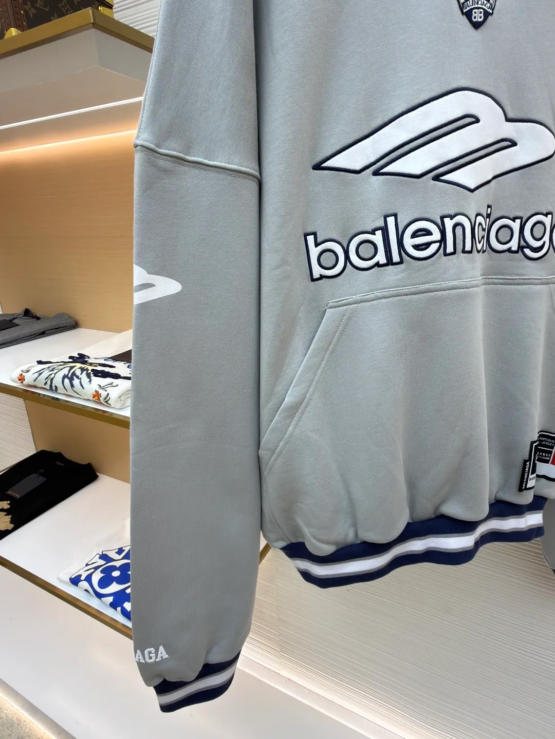 Balenciaga 3B football Polo hoodie ●Original version: purchased and developed by 10767 ●Item number: 1682334-B05 ●Fabric: cotton fabric ●Technology: embroidery applique production ●Color: gray ●Version: loose fit ●Weight: about 885 grams ●Size: XS-S-M-L ●Description: The neckline adopts a half-open button design and is decorated with metal badges to enhance the layered look; the main body of the garment presents the brand logo through three-dimensional foam printing technology, and the grayscale gradient effect enhances the visual texture. The cuffs and hem are edged with contrasting ribbing, which has moderate elasticity and is not easily deformed; a collage label is embedded in the left hem, and the details echo the brand's street style. The partial logo embroidery on the shoulders and cuffs echoes the main pattern. The overall craftsmanship takes into account practical wearability and brand recognition, making it suitable for daily casual or trendy looks. The overall wiring is straight and delicate, the fabric is comfortable and soft, and the color is consistent without color difference. It can be matched with the same style to create a fashionable look and control various occasions. Customized accessories, complete with three standards, same style for men and women!