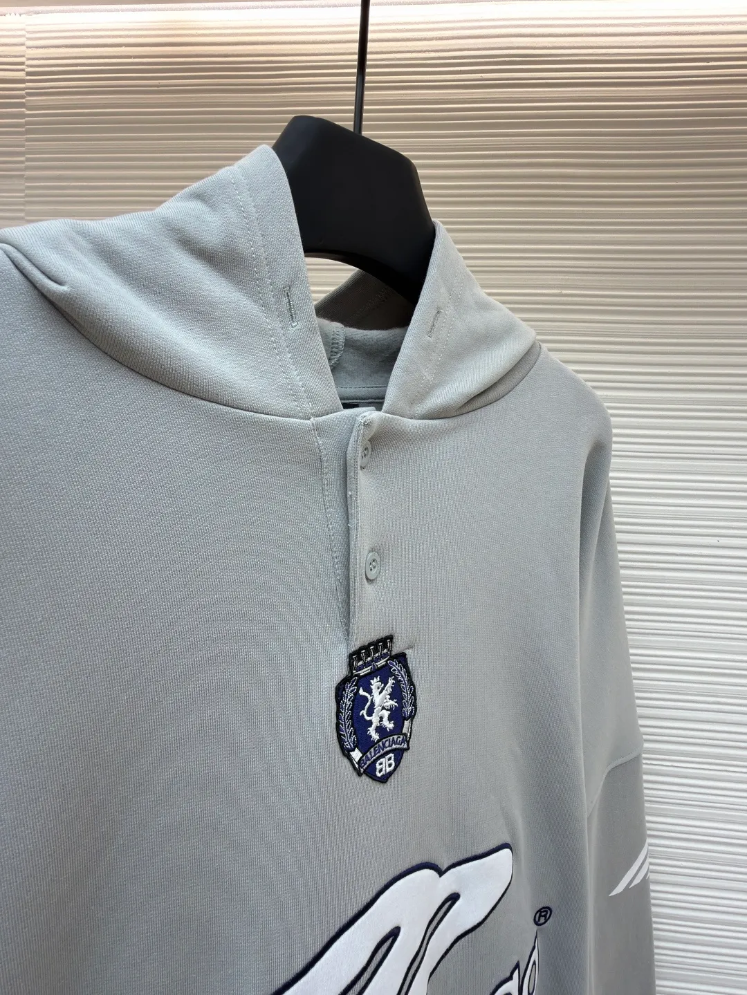 Balenciaga 3B football Polo hoodie ●Original version: purchased and developed by 10767 ●Item number: 1682334-B05 ●Fabric: cotton fabric ●Technology: embroidery applique production ●Color: gray ●Version: loose fit ●Weight: about 885 grams ●Size: XS-S-M-L ●Description: The neckline adopts a half-open button design and is decorated with metal badges to enhance the layered look; the main body of the garment presents the brand logo through three-dimensional foam printing technology, and the grayscale gradient effect enhances the visual texture. The cuffs and hem are edged with contrasting ribbing, which has moderate elasticity and is not easily deformed; a collage label is embedded in the left hem, and the details echo the brand's street style. The partial logo embroidery on the shoulders and cuffs echoes the main pattern. The overall craftsmanship takes into account practical wearability and brand recognition, making it suitable for daily casual or trendy looks. The overall wiring is straight and delicate, the fabric is comfortable and soft, and the color is consistent without color difference. It can be matched with the same style to create a fashionable look and control various occasions. Customized accessories, complete with three standards, same style for men and women!