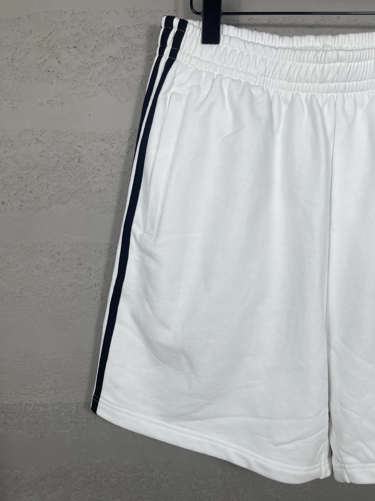 🅿️240 real shots [Top version. Official website quality] BALENCI*GA/Paris. 2025 new model. Paris co-branded adidas clover embroidered side seams. Invisible zipper shorts at the pocket. Brick cabinet synchronization. Genuine product developed at the first time, please print and compare! The fabric is made of Paris ZP custom-woven and dyed 100% cotton terry sweatshirt. The weight is 460 grams. The cloth surface is clean. The cloth pattern is clear and the hand feels soft and comfortable. The embroidery uses an imported Tajima embroidery machine. The letters are clear and the effect is three-dimensional. The version adopts a loose version. Same style for men and women. Code: BL257029 Color: black, white Size: XS S M L