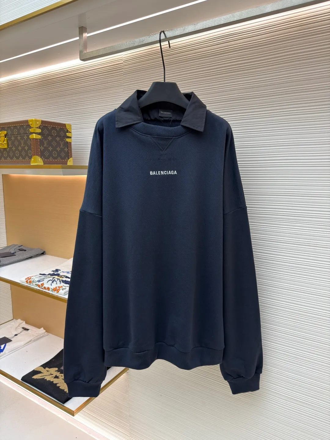 Balenciaga fake two-piece collared crew neck sweatshirt ●Original version: purchased and developed by 7652 ●Item number: 1681727-A50 ●Material: combed cotton fabric ●Technology: embroidery production ●Color: royal blue ●Version: fitted version ●Weight: about 785 grams ●Size: S-M-L-XL ●Description: The fabric is made of custom-woven and dyed 400 grams combed cotton, and the weight is the key indicator to measure the thickness of the fabric. 400 grams belongs to the high weight category, which gives the sweatshirt excellent stiffness, drape and warmth. This sense of weight does not attach softly to the body, but can build the architectural silhouette that Demna is pursuing. During the spinning process, the shorter cotton fibers and impurities are removed, leaving longer, stronger fibers. This makes the final fabric smoother, stronger, and less prone to pilling, essentially improving durability and premium feel. The splicing line between the collar and the sweatshirt body must be clean and neat, and the transition relationship between the inner and outer layers needs to be calculated just right. This is a kind of "deliberate randomness" whose complexity is much higher than actually wearing two pieces of clothing. It challenges the traditional definition of "a piece of clothing" and is the embodiment of Demna's signature deconstruction and reorganization techniques. It combines two clothing with different functions (formal collar and casual sweatshirt) to create a new species full of contradictions and interest. The overall wiring is straight and delicate, the fabric is comfortable and soft, and the color is consistent without color difference. It can be matched with the same style to create a fashionable look and control various occasions. Customized accessories, complete with three standards, same style for men and women!