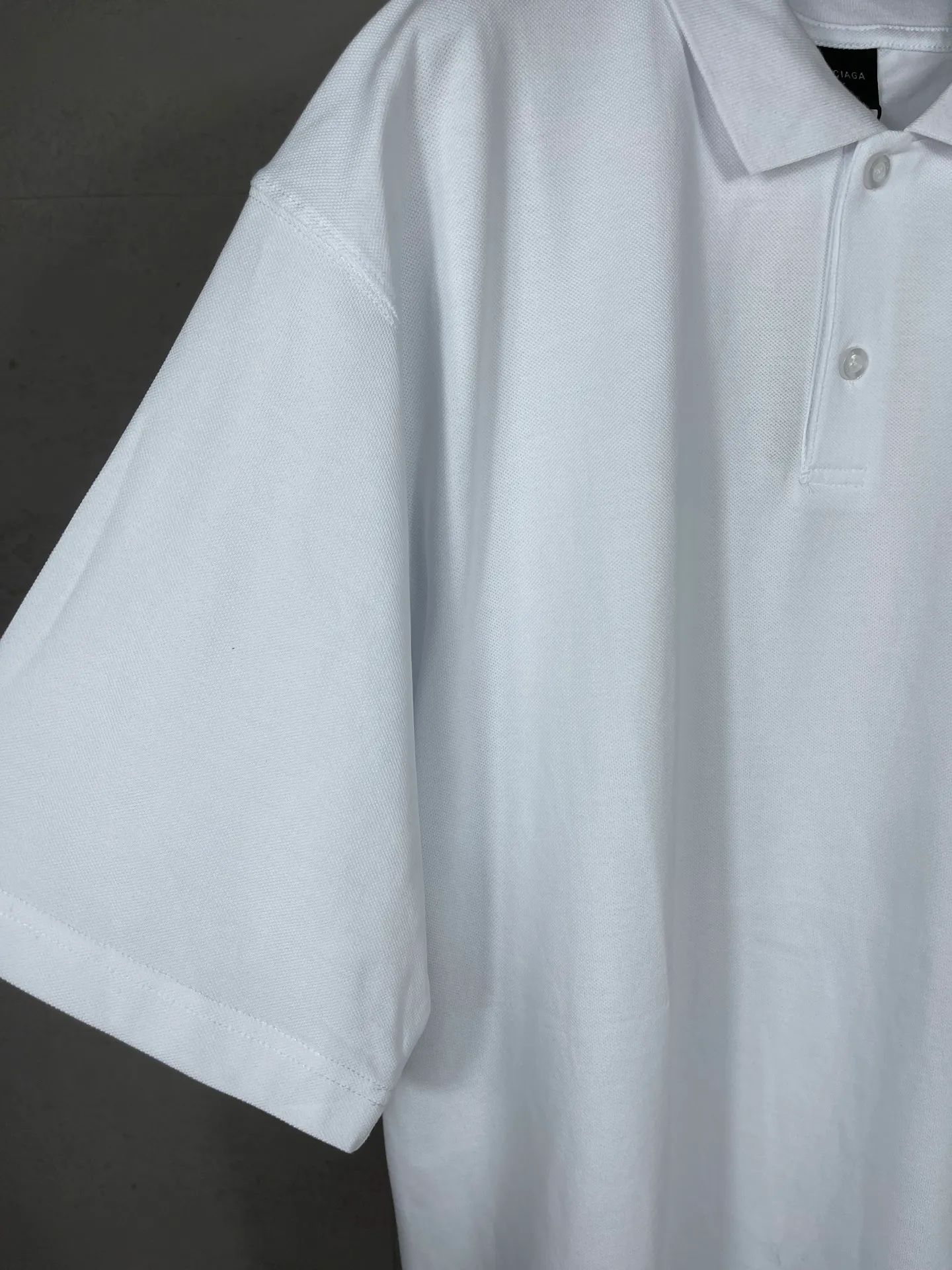 🅿️220 photos [Top version. Official website quality] BALENCI*GA/Paris #2025 new Paris letter LOGO embroidered POLO shirt, full of design, welcome to compare. The fabric is made of Paris ZP custom-woven and dyed cotton pique, with a weight of 260 grams. The cloth surface is clean. The cloth pattern is clear, soft and comfortable. The threads are woven and dyed with no color difference. The embroidered LOGO is embroidered using imported Tajima embroidery machine. The effect is three-dimensional. Restore the brick cabinet, adopt OS loose shoulder style. Same style for men and women. Coding: BL252218 Color: black, white Size: XS S M L