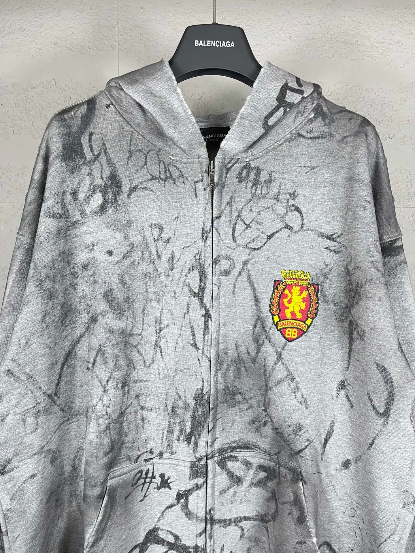 🅿️456 real photos [Top version. Official website quality] BALENCI*GA/Paris co-branded Manchester United. 24 latest. Hand-painted. Worn. Washed. Distressed. Worn. Inkjet painting. Graffiti. Zipper cardigan hooded sweatshirt. The embroidered insignia is heavily tattered. Top-quality board. Comparisons are welcome. The fabric is made of Paris ZP custom-woven and dyed cotton double yarn. Weighing 260 grams, the cloth surface is clean. The cloth pattern is clear, soft and comfortable. The threads are dyed with no color difference. The front pattern embroidery is made with imported machine embroidery. The color of the chapter mark is the same. The embroidery and border are embroidered. The chapter mark is worn and distressed to match the brick cabinet. Ready-made clothes are washed and distressed. Painted with graffiti. The entire piece of clothing is restored with overweight craftsmanship. Jubie market produces pictures based on pictures. Welcome to compare. The version adopts OS loose shoulder design. Same style for men and women. Code: BL238079 Color: gray, red, lake blue Size: XS S M L