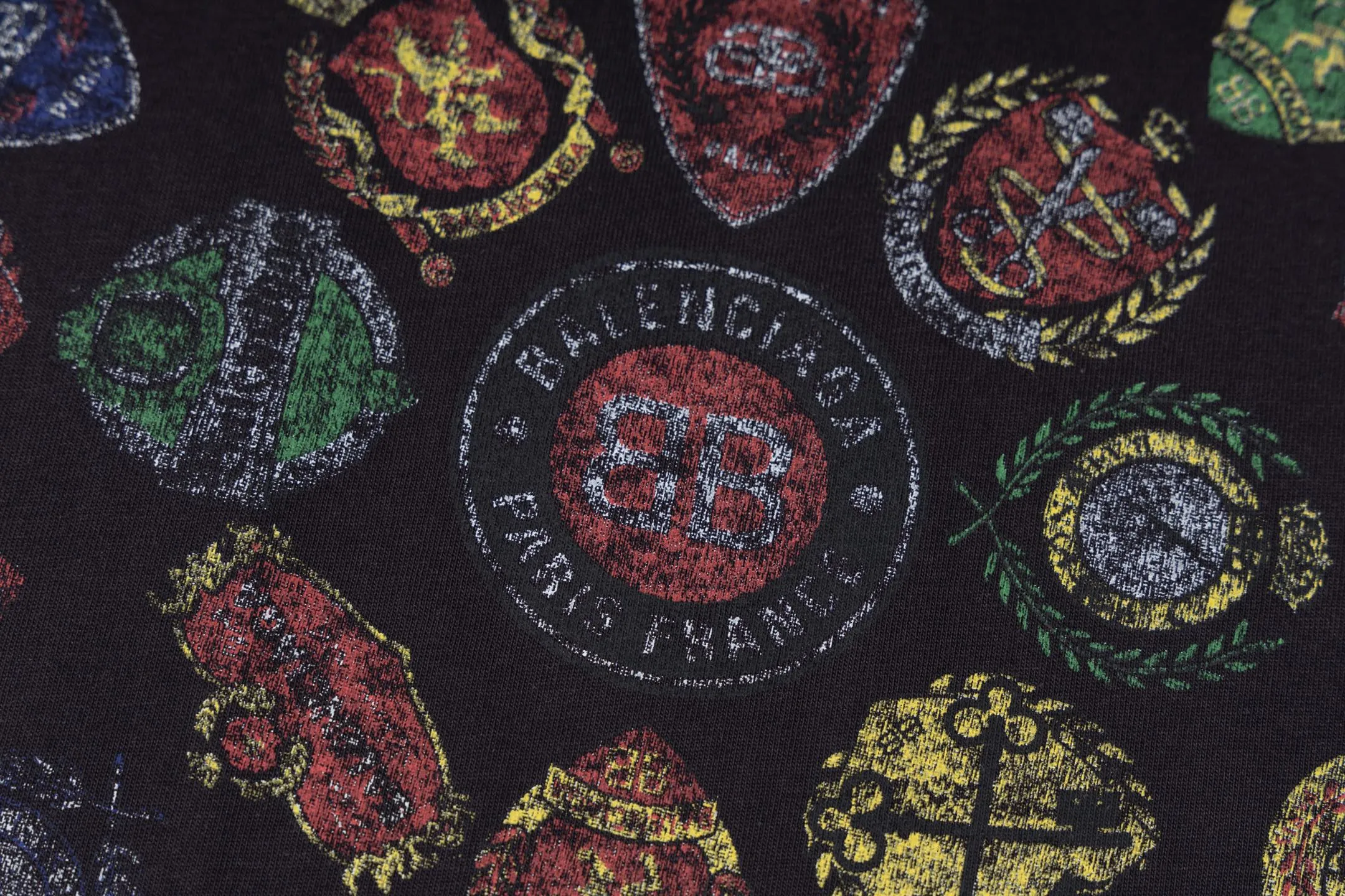 🅿️290 [Exclusive supply] BLCG 25FW badge printed short sleeves (black) The fabric is made of 24S 185g double yarn special textile compact cotton, and the rib is made of 32S 340g double yarn stretch rib. The structure of pure cotton fabric is plain weave. The surface of the fabric is smooth and delicate, and the texture is tight. It has good moisture absorption, breathability and comfort, and can keep you dry and comfortable. Due to its tight spinning process, it also has good wrinkle resistance and durability, making it suitable for long-term wear or use. The multi-layer superposition process of dark flower paste dots uses precision screen technology to cover the fabric with translucent printing paste through multiple layered printing. Each layer is laminated and fused with micron-level tolerances. Through subtle changes in the thickness and density of the slurry, an invisible pattern with a transition between dark and light is formed on the surface of the fabric. This technology replaces color contrast with physical accumulation, and uses the diffuse reflection of light on concave and convex surfaces to present a looming light and shadow relief effect, creating a high-end print with both visual haziness and tactile three-dimensionality, which perfectly fits the low-key and luxurious design aesthetics. Size:XS-S-M-L