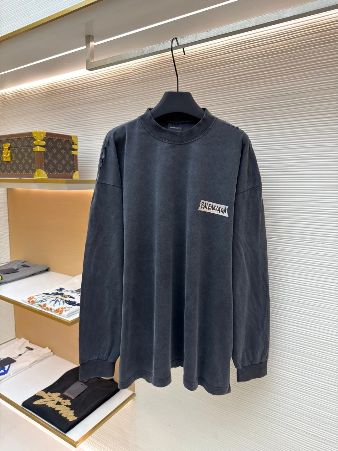 Balenciaga imitation paper white tape long-sleeved T-shirt ●Original version: Purchased and developed by 7724 ●Item number: 1681813-A55 ●Material: combed cotton fabric ●Technology: printed distressed production ●Color: gray ●Type: loose version ●Weight: about 340 grams ●Size: XS-S-M-L ●Description: Strictly follow the original specifications, using custom-woven 280 grams of combed cotton. This weight ensures a crisp and stylish frame of the garment and avoids the soft feeling of ordinary fabrics. The combing process removes short fibers and impurities, making the yarn tougher and the woven cloth surface smooth and hairless, providing the perfect "canvas" for subsequent printing and distressing. In order to achieve the unique, almost paper-like slightly cracked texture and matte texture of the original, we developed and used a special customized slurry. After this slurry is printed on the fabric through screen printing, it will form a layer of coating with a certain thickness and toughness. After drying, it can naturally simulate the texture of paper and a slight brittle and hard touch. This is a complex effect that is completely beyond the reach of ordinary glue or thermal transfer film. After the garments are stitched and printed, they will go through a critical process of "frying with salt and aging". The ready-made garments are washed with a specific proportion of industrial salt in a large drum machine for a long time. During the tumbling, the salt particles will cause random and natural wear and tear on the fibers, seams and edges of the printed coating of the fabric. The fading, slightly whitening and softening effects caused by this kind of physical wear cannot be replaced by chemical washing. It gives each finished product a unique, natural retro flavor and traces of wear, perfectly replicating the "unfinished feel" and industrial aesthetics pursued by the original show model. From the custom-woven and dyed 280-gram combed cotton base, to the hand-made imitation paper printing on the silk screen using special slurries, and finally to the unique time texture brought about by fried salt and distressing - these three links are intertwined, forming a complete and complex imitation process chain. Each of these choices is a complete negation of "fast food" products and a respect and restoration of high-end fashion production. The final product is not only a piece of clothing, but also an "industrial art piece" worth tasting and collecting. The overall wiring is straight and delicate, the fabric is comfortable and soft, and the color is consistent without color difference. It can be matched with the same style to create a fashionable look and control various occasions. Customized accessories, complete with three standards, same style for men and women!