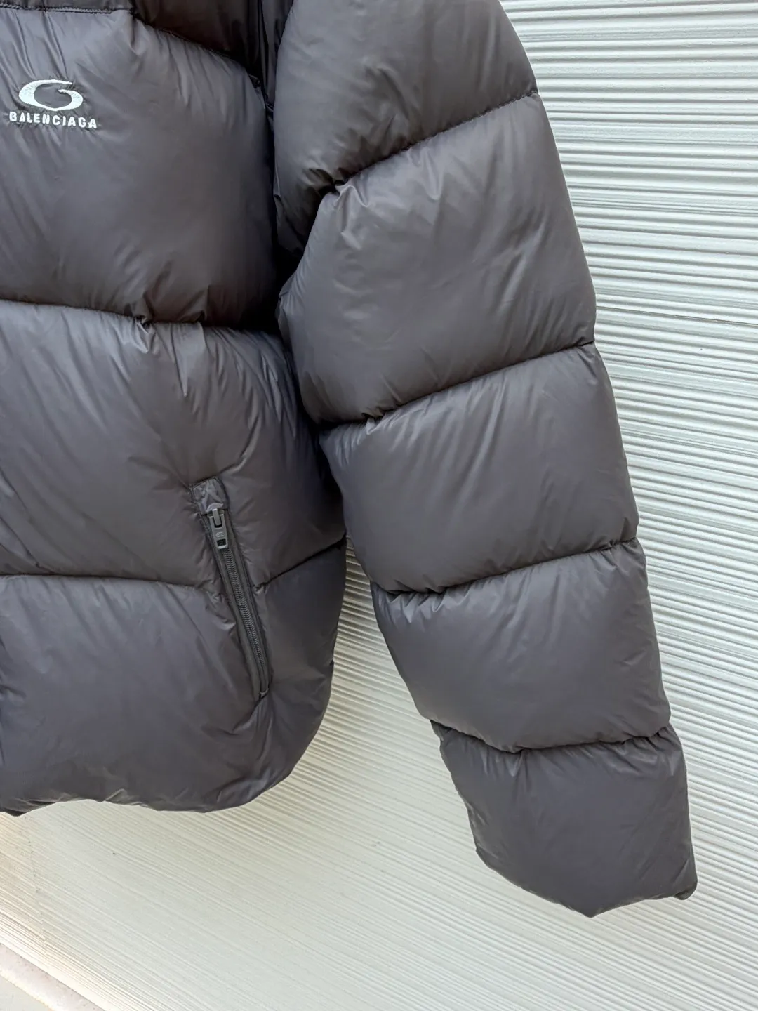 Balenciaga single-loop embroidery down jacket ●Original version: Purchased and developed by 12336 ●Item number: 1681876-D15 ●Fabric: white duck down fabric ●Technology: mechanical down filling ●Color: gray ●Version: loose version ●Weight: about 750 grams ●Size: S-M-L-XL ●Description: Custom-developed high-count and high-density woven fabric is the cornerstone of its high-end texture. High count means that the yarns are extremely fine, resulting in a finely textured and silky-touch surface; high density gives the fabric excellent stiffness, abrasion resistance and wind resistance. It avoids the rough feeling of ordinary cotton canvas and presents a low-key and precise micro-gloss, which provides a perfect and stable foundation for subsequent embroidery and hemming processes. The filling process needs to ensure that the cotton body is evenly distributed within the quilting grid without holes or agglomerations, which requires extremely high filling accuracy. The hemming is like the steel frame of a building, which strengthens the overall silhouette of the vest and makes the lines sharper and clearer, reflecting the brand's meticulous attitude towards tailoring. Dense embroidery on this thin and dense fabric can easily cause the fabric to shrink and deform. The brand will use special water-soluble lining or hot-melt lining on the bottom layer of embroidery. These linings will disappear after the embroidery is completed, ensuring that the pattern is smooth and crisp without destroying the flexibility of the fabric itself. This is the ultimate test of the combination of handicrafts and technology. The overall wiring is straight and delicate, the fabric is comfortable and soft, and the color is consistent without color difference. It can be matched with the same style to create a fashionable look and control various occasions. Customized accessories, complete with three standards, same style for men and women!