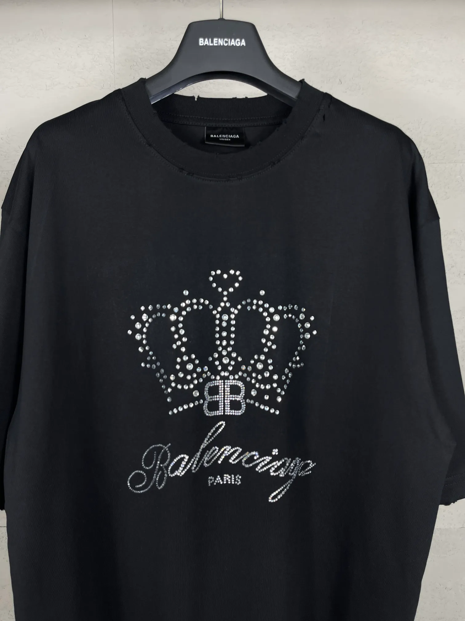 🅿️200 Actual pictures [Top version. Official website quality] BALENCI*GA/Paris BALENCI*GA# New style, classic crown LOGO on the front, hot-drilled, washed and distressed short-sleeved T-shirt. Brick cabinet synchronization. The fabric is made of Paris ZP custom-woven and dyed 100% cotton double yarn compact cotton. The weight is 260 grams, the cloth surface is clean. The cloth pattern is clear. Soft and comfortable. Good color fastness. Not easy to change color. The threads are woven and dyed with no color difference. The front perm is made of imported diamonds, which have good gloss and are not easy to fall off. The finished garments are washed and worn. Jubie market makes goods based on pictures. Comparisons welcome. Restore brick cabinet. The version adopts OS loose shoulder style. Same style for men and women. Code: BL223373 Color: Black Size: XS S M L