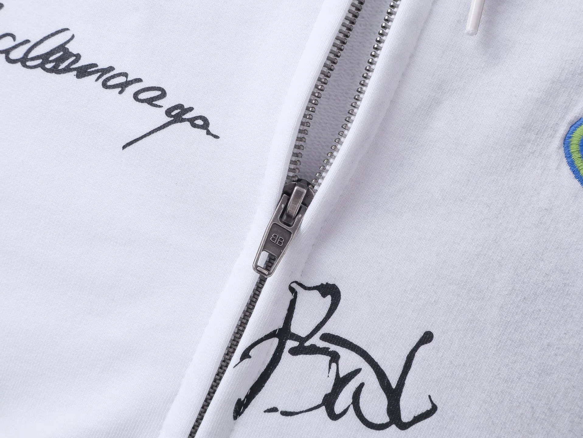 🅿️430 real photos [Top version. Official website quality] BALENCI*GA/Paris #2026 new style Raglan sleeves color block signature printing. Embroidered LOGO washed and distressed hand-painted graffiti new hooded zipper cardigan sweatshirt #2026 Brick cabinet synchronization Overweight craftsmanship. Welcome to compare. The fabric is made of Paris ZP custom-woven and dyed cotton sweatshirt. The weight is 460 grams. The cloth surface is clean. The cloth pattern is clear, soft and comfortable. The threads are dyed with no color difference. The signature is printed with environmentally friendly glue, and the classic letter LOGO is embroidered with an imported Tajima embroidery machine. The letters are clear and the effect is three-dimensional. Garment wash-worn hand-drawn graffiti. Restore brick cabinet, adopt OS loose shoulder style. Same style for men and women. Code: BL259980 Color: black, white Size: XS S M L