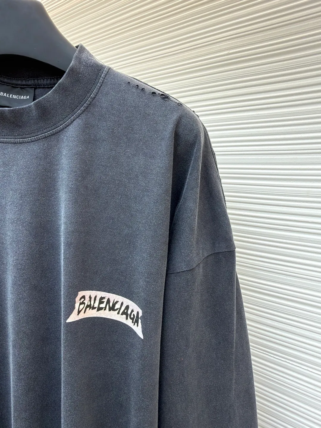 Balenciaga imitation paper white tape long-sleeved T-shirt ●Original version: Purchased and developed by 7724 ●Item number: 1681813-A55 ●Material: combed cotton fabric ●Technology: printed distressed production ●Color: gray ●Type: loose version ●Weight: about 340 grams ●Size: XS-S-M-L ●Description: Strictly follow the original specifications, using custom-woven 280 grams of combed cotton. This weight ensures a crisp and stylish frame of the garment and avoids the soft feeling of ordinary fabrics. The combing process removes short fibers and impurities, making the yarn tougher and the woven cloth surface smooth and hairless, providing the perfect "canvas" for subsequent printing and distressing. In order to achieve the unique, almost paper-like slightly cracked texture and matte texture of the original, we developed and used a special customized slurry. After this slurry is printed on the fabric through screen printing, it will form a layer of coating with a certain thickness and toughness. After drying, it can naturally simulate the texture of paper and a slight brittle and hard touch. This is a complex effect that is completely beyond the reach of ordinary glue or thermal transfer film. After the garments are stitched and printed, they will go through a critical process of "frying with salt and aging". The ready-made garments are washed with a specific proportion of industrial salt in a large drum machine for a long time. During the tumbling, the salt particles will cause random and natural wear and tear on the fibers, seams and edges of the printed coating of the fabric. The fading, slightly whitening and softening effects caused by this kind of physical wear cannot be replaced by chemical washing. It gives each finished product a unique, natural retro flavor and traces of wear, perfectly replicating the "unfinished feel" and industrial aesthetics pursued by the original show model. From the custom-woven and dyed 280-gram combed cotton base, to the hand-made imitation paper printing on the silk screen using special slurries, and finally to the unique time texture brought about by fried salt and distressing - these three links are intertwined, forming a complete and complex imitation process chain. Each of these choices is a complete negation of "fast food" products and a respect and restoration of high-end fashion production. The final product is not only a piece of clothing, but also an "industrial art piece" worth tasting and collecting. The overall wiring is straight and delicate, the fabric is comfortable and soft, and the color is consistent without color difference. It can be matched with the same style to create a fashionable look and control various occasions. Customized accessories, complete with three standards, same style for men and women!