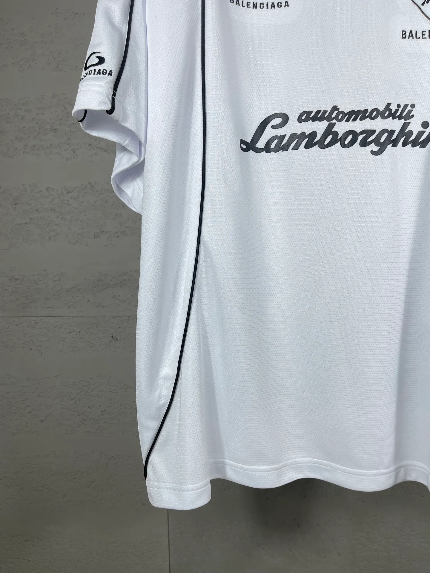 🅿️226 Actual pictures [Top version. Official website quality] BALENCI*GA/Paris co-branded Lamborghini jersey, printed embroidery on the front and back, embroidered on the left and right sleeves, multi-position short-sleeved T-shirt #overweight craftsmanship. SS25 latest model. Research and development at the first time, different market currencies. Comparisons welcome. The fabric is made of custom-woven sports fabric that absorbs moisture and is comfortable and dry. Whether you are doing sports or fitness or going out on the street every day, you can easily become the center of attention. Stretch ribbing at neckline. Weighing 260 grams, the cloth surface is clean. The cloth pattern is clear, soft and comfortable. The threads are dyed with no color difference. The printing uses imported environmentally friendly rubber paddles. The embroidery is done using imported Tajima embroidery machines. The pattern letters are clear, three-dimensional and without burrs. Jubie market produces pictures based on pictures. Welcome to compare. The version adopts OS loose shoulder design. Same style for men and women. Code: BL253691 Color: black, white Size: XS S M L