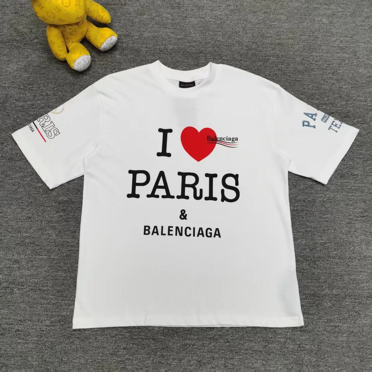 [Top version. Official website quality] BALENCI*GA/Paris. SS25 latest model, front and back left and right sleeves I Love Paris & Balenciaxx art printed short-sleeved T-shirt. Brick cabinet synchronization. Genuine product developed at the first time, happy to print and compare! The fabric is made of Paris ZP custom-woven and dyed cotton double yarn. Weighing 260 grams, the cloth surface is clean. The cloth pattern is clear, soft and comfortable. The threads are dyed with no color difference. The printing uses environmentally friendly imported materials. The letters are clear and the effect is three-dimensional. The version adopts OS loose shoulder design. Same style for men and women. Color: white, black. Size: XS S M L P270