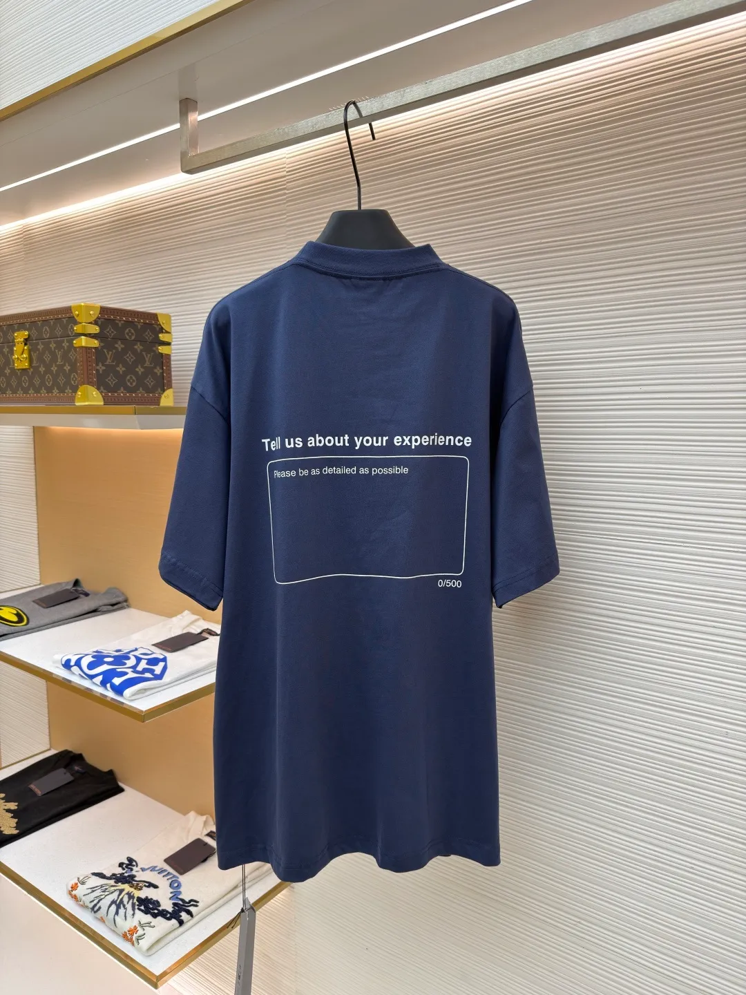 Balenciaga star embroidered short sleeves [comes with marker] ●Item number: 1682275-A20 ●Material: combed cotton fabric ●Technology: embroidery printing ●Color: blue ●Version: loose fit ●Weight: about 355 grams ●Size: XS-S-M-L ●Description: This navy blue short-sleeved T-shirt is made of high-density piqué mesh cotton fabric. The fabric has been custom-woven and dyed. The navy blue tone is uniform and not easy to fade. The breathable structure formed by the piqué texture makes the wearer more refreshing. At the same time, the fabric has excellent stiffness and can support the loose shoulder silhouette. The five-star pattern on the chest adopts double-track offset printing + inlay embroidery process. First, the outline of the stars is outlined with high-temperature embossing using matte silicone material. The thickness of the silicone layer is controlled at 0.3mm to ensure softness and no irritation to the skin. White embroidery thread is then used to fill in inlay along the edge of the silicone to give the star pattern a three-dimensional relief texture. The stitch density of each star reaches 12 stitches/cm, and the pattern alignment error does not exceed 0.1cm. The neckline is designed with a small stand-up collar, which is woven with ribs of the same fabric. It is not easy to loose after high-temperature pre-shrinking treatment. The side seams are spliced ​​with a seamless buried clip process to reduce friction when wearing. The overall process takes into account the texture and wearing comfort. The overall wiring is straight and delicate, the fabric is comfortable and soft, and the color is consistent without color difference. It can be matched with the same style to create a fashionable look and control various occasions. Customized accessories, complete with three standards, same style for men and women!